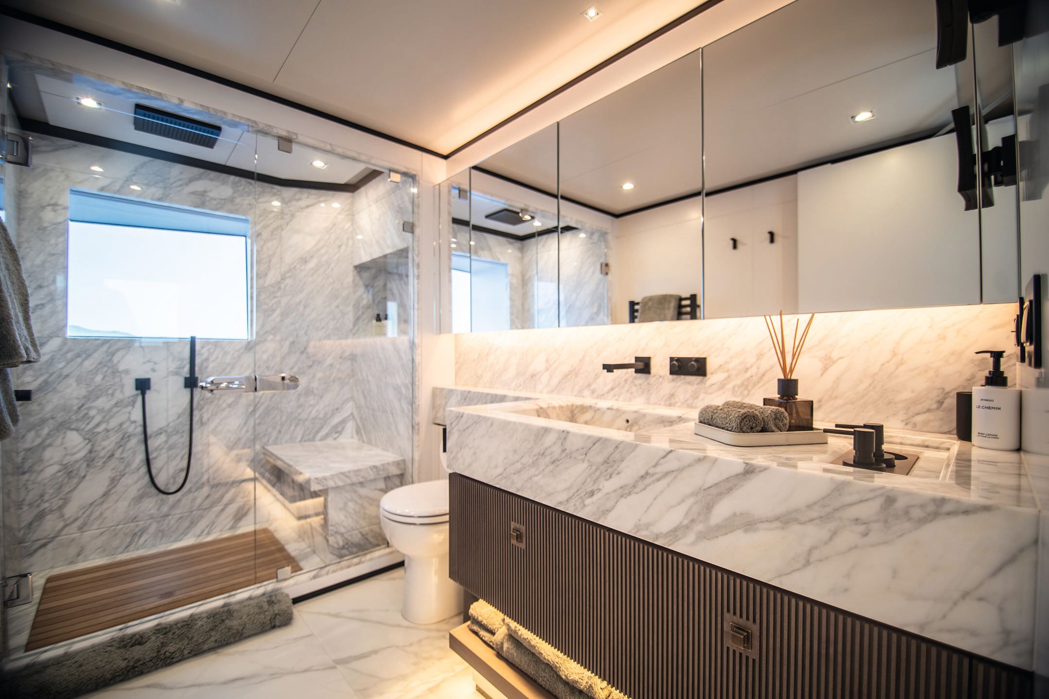 En-suite with marble sinks and shower surround