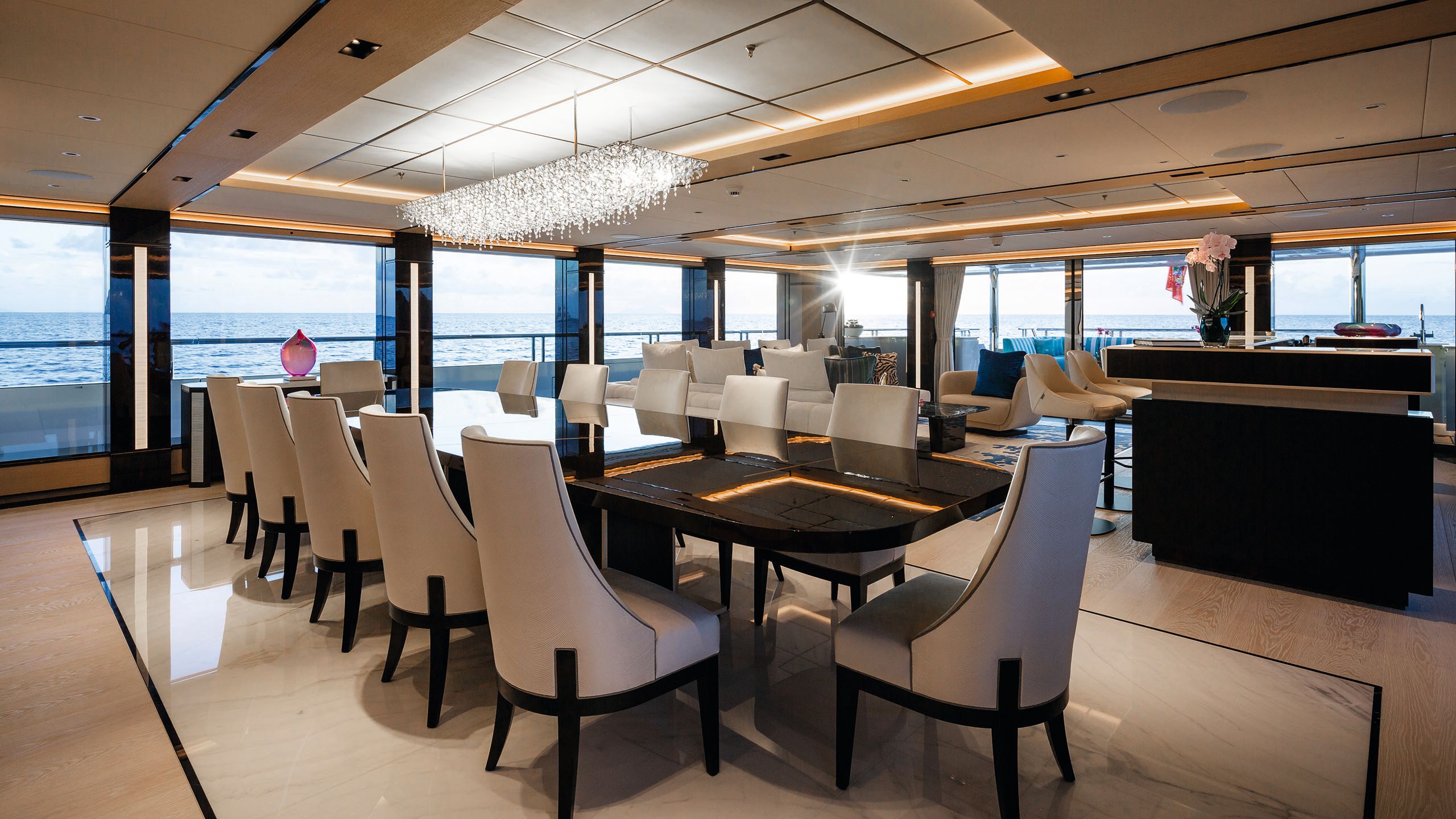 Long black dining table with high-backed neutral dining chairs