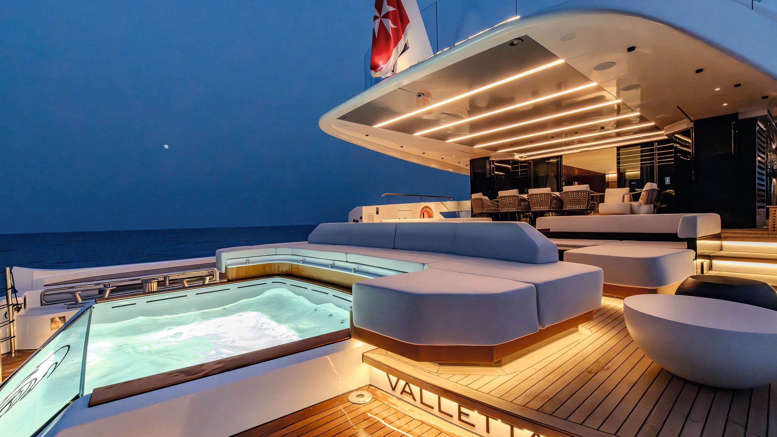 The pool on Night Fury II lit up at night. There are large grey sunpads surrounding it