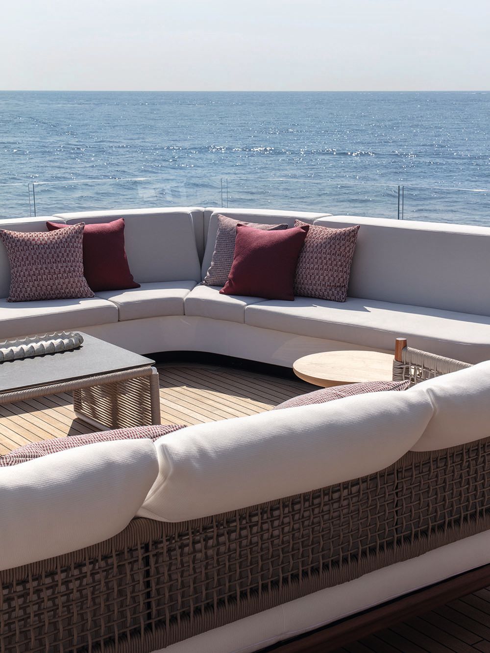An outdoor seating area on Frette - the sofas are a neutral colour with burgundy and patterned throw cushions