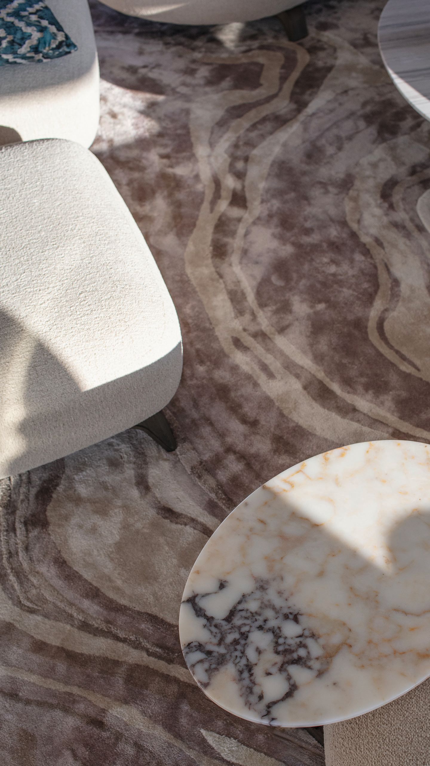 Overhead view of the carpet which is an abstract swirled pattern in browns and beige