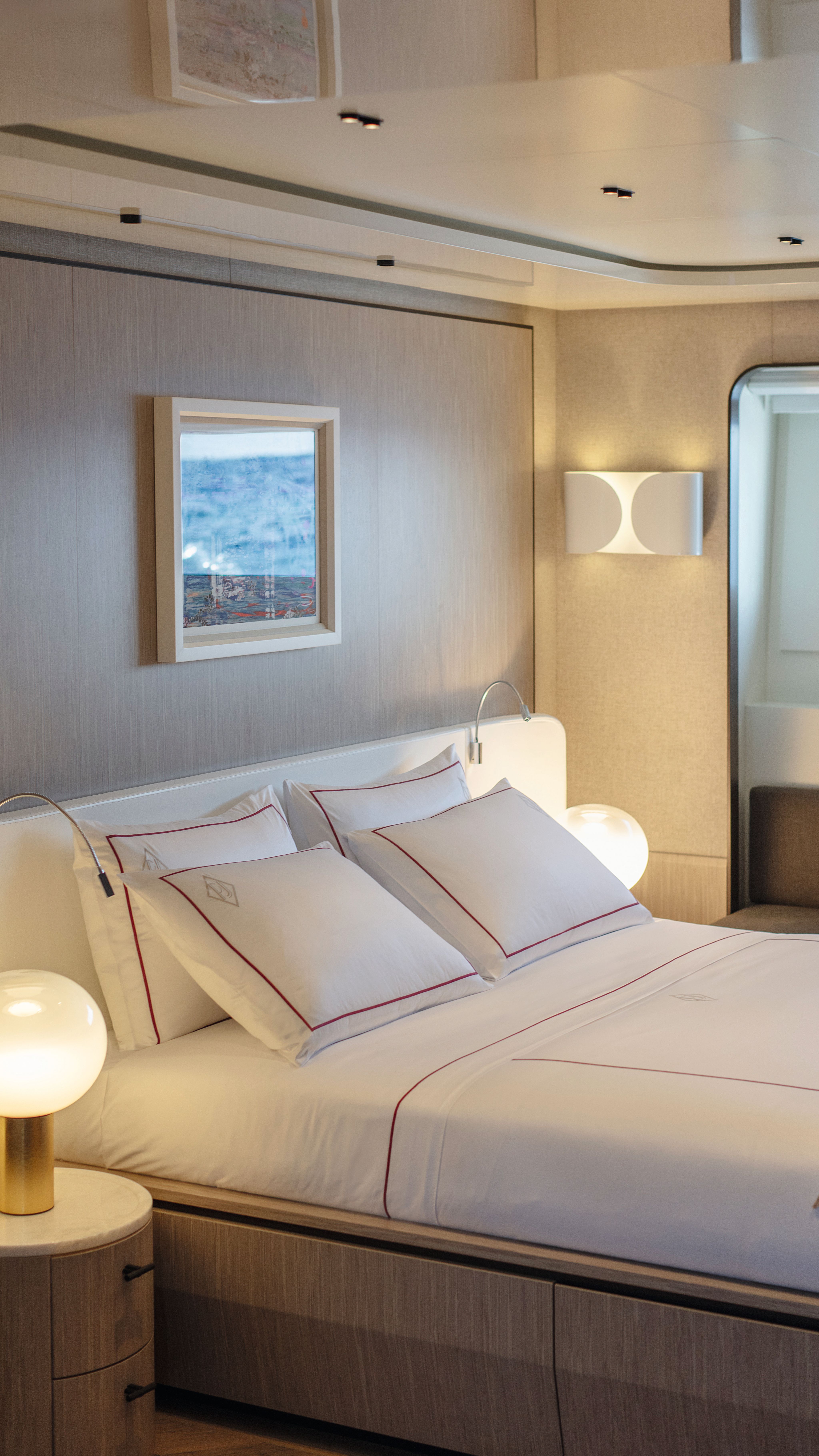 A bed made with white linens and red edging