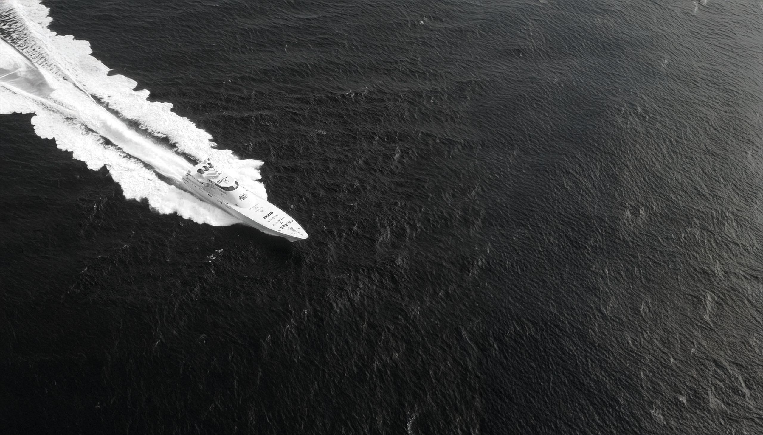 A black and white image of a vessel in the water taken from above