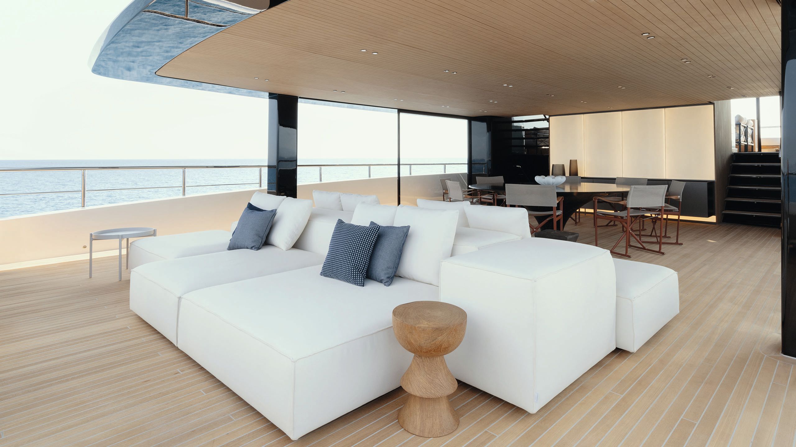 White sun loungers, some facing out towards the sea and some facing inwards to the aft deck dining area