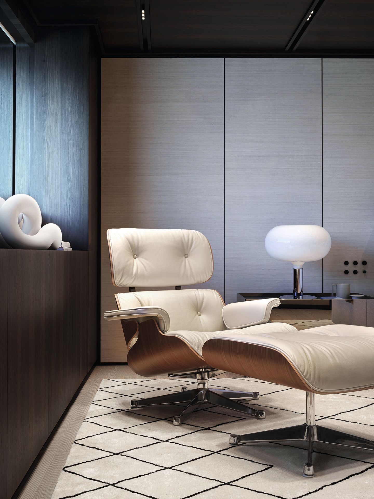 A white leather reclining chair with matching footrest and lamp to the left