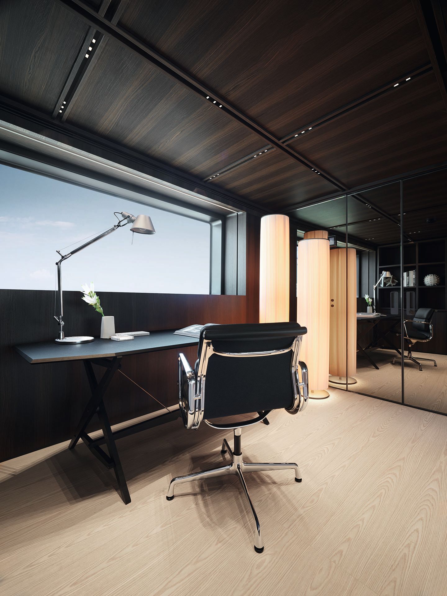 Black and chrome chair at a dark wooden desk with silver angle poise lamp