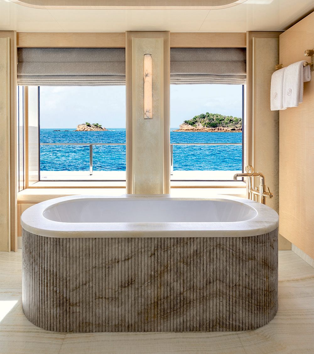 White standalone bath with quartz surround and gold taps