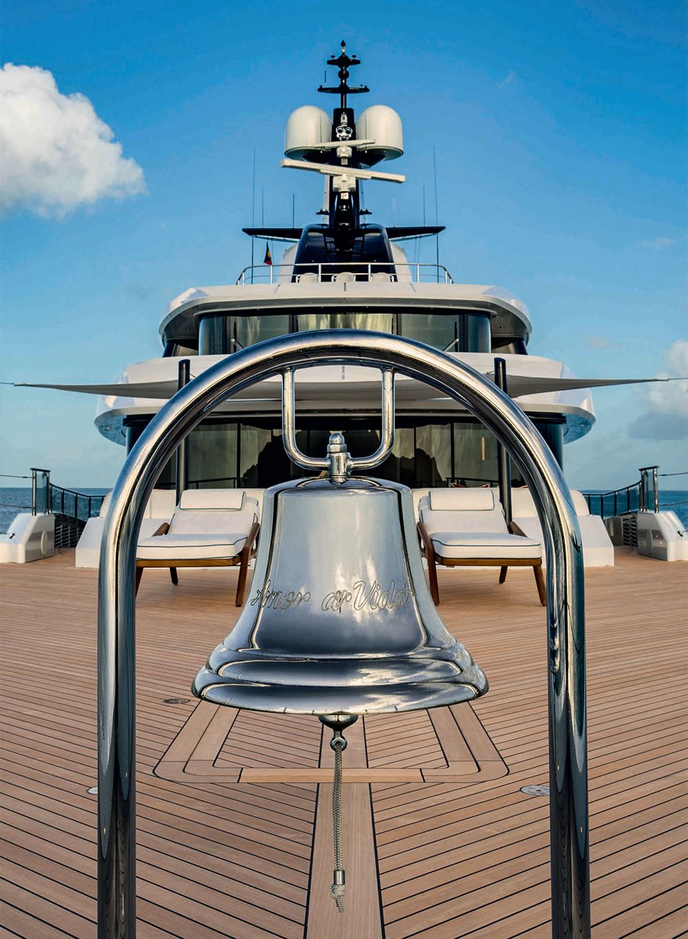 Close-up of a silver bell on an exterior deck engraved with the boat's name