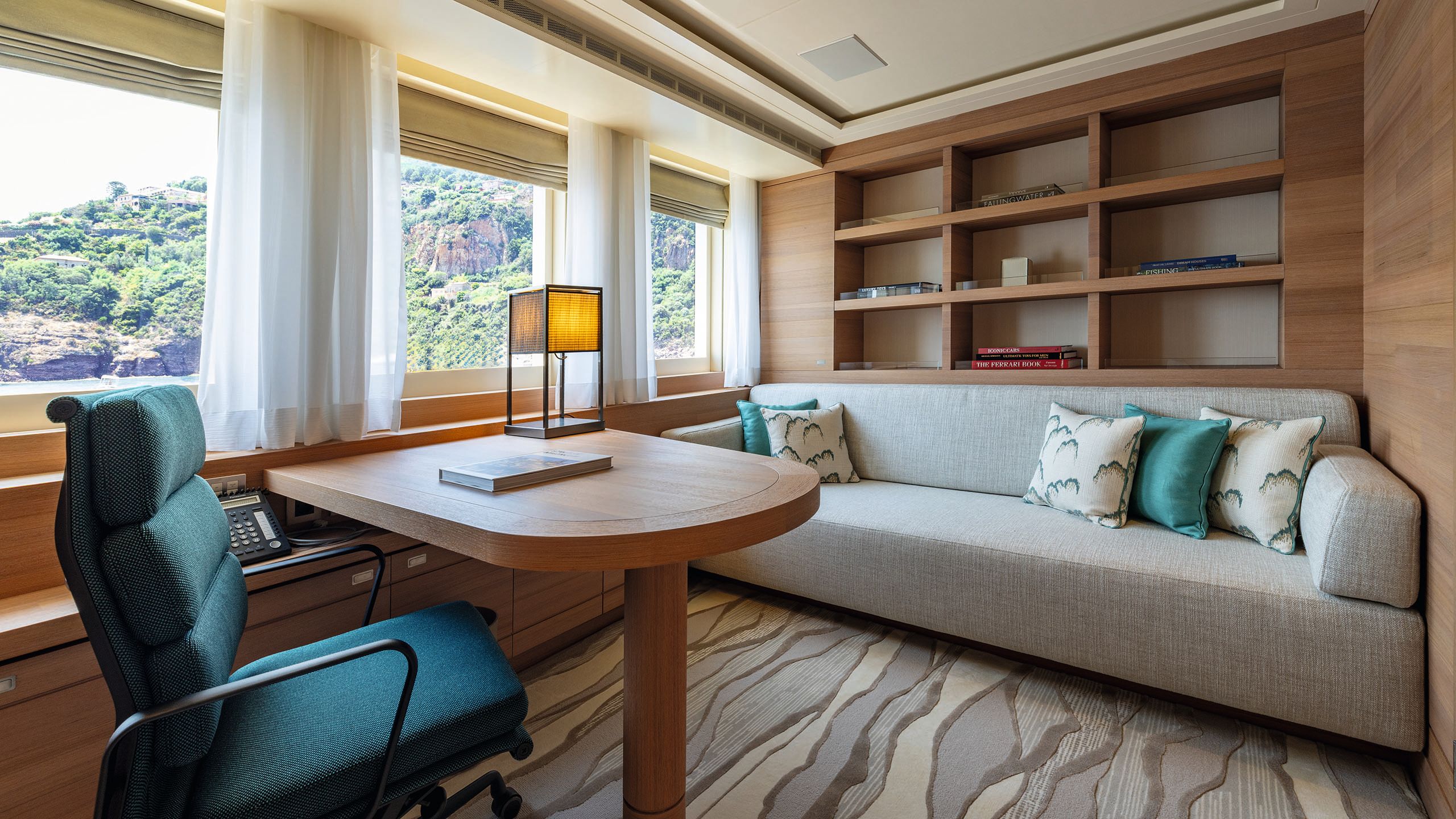 After, the char is a teal colour and the sofa is light grey. There is open shelving behind it and a Japense-style cuboid lamp on the table