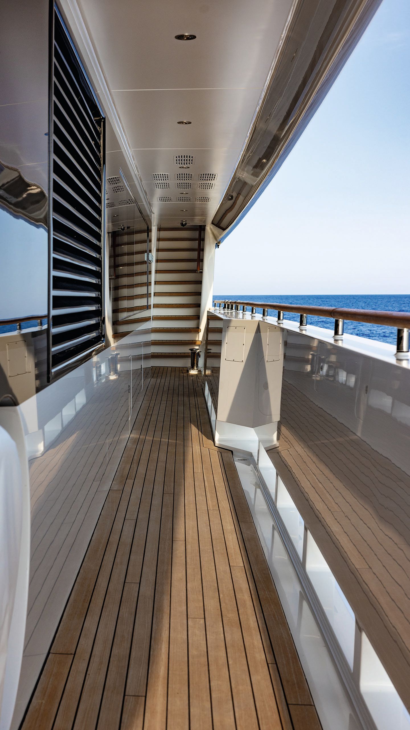 Looking down the side of a deck - there is a staircase at the end and a railing to the right