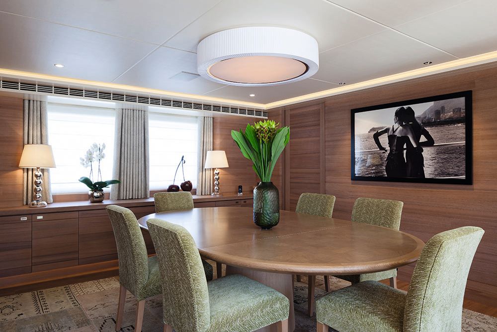 The dining table was a light walnut colour with green chairs and lamps with chrome stems