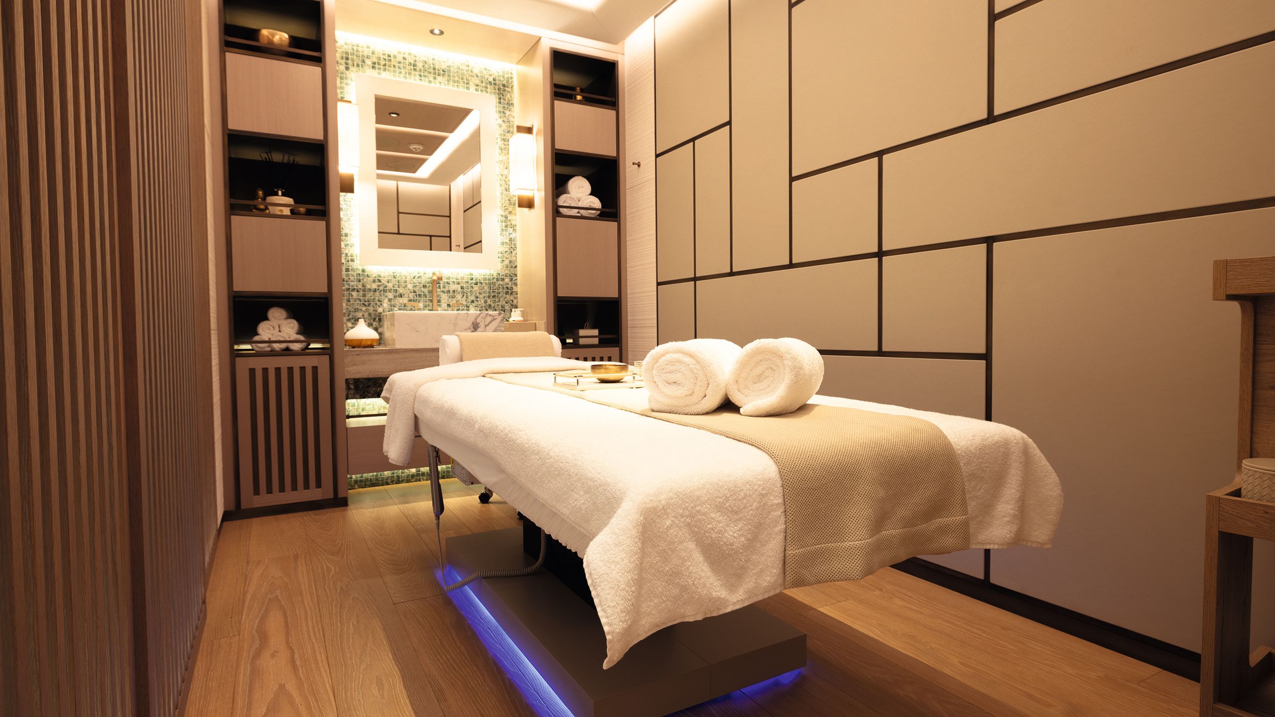 Massage table with towels in soft-lit spa room
