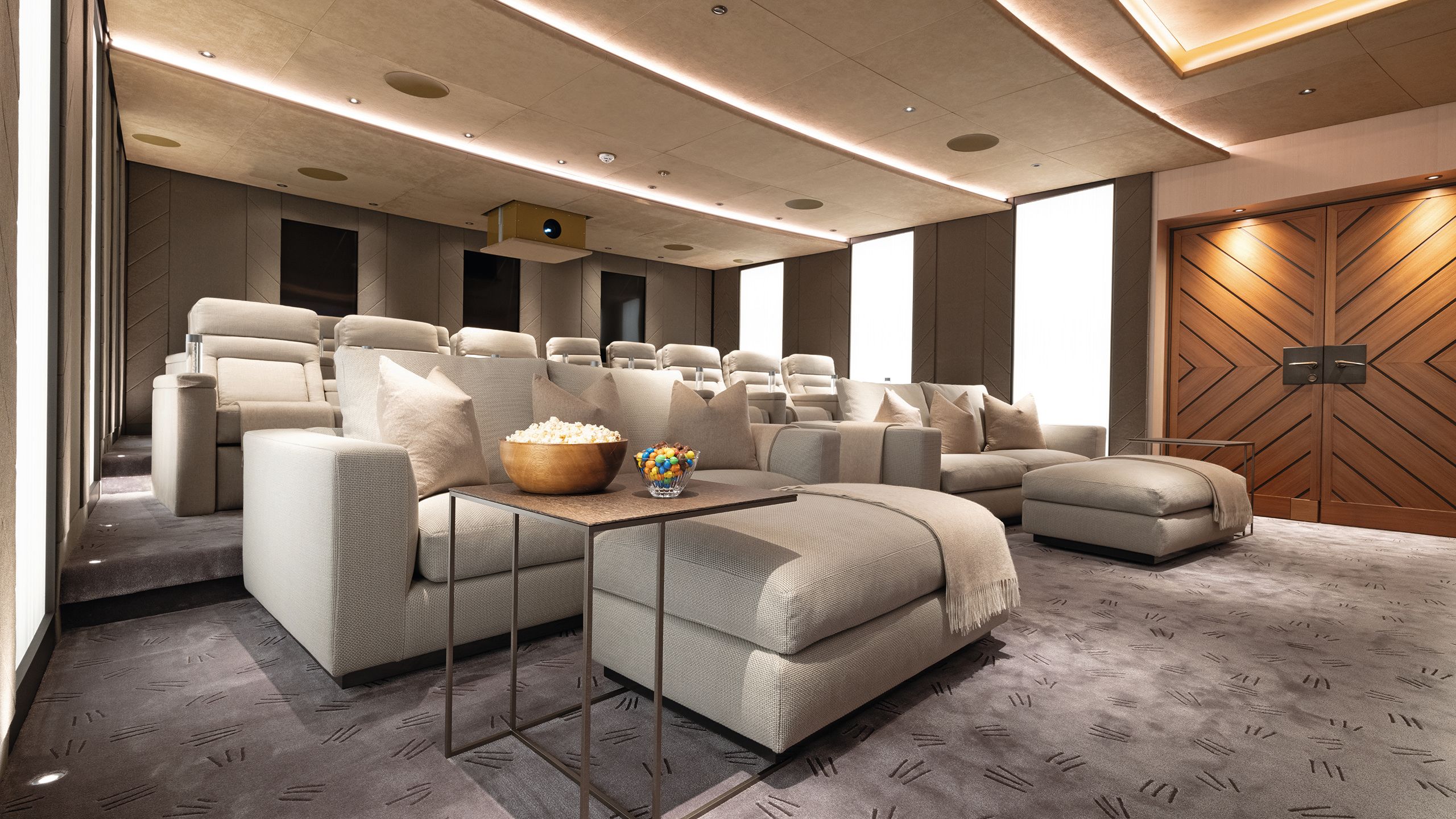 Cinema with beige seats in rows and table with popcorn