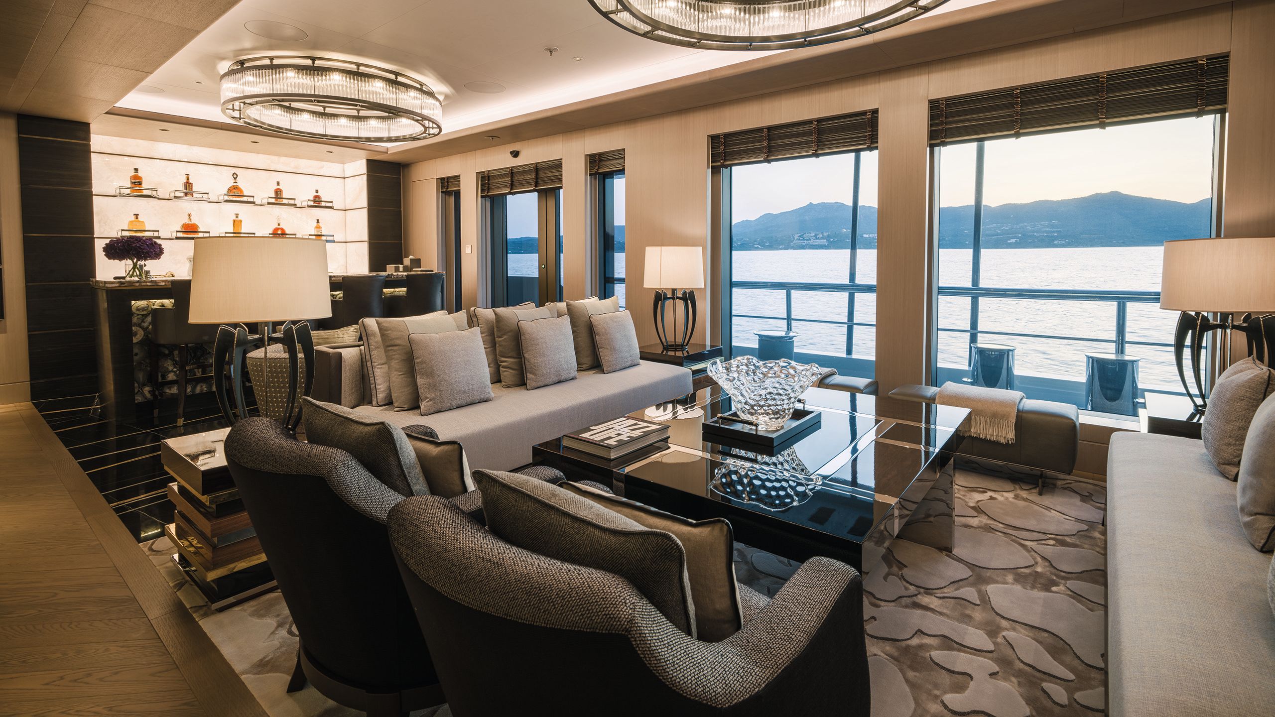 Lounge area in neutral colours with three sofas and large black coffee table in the middle