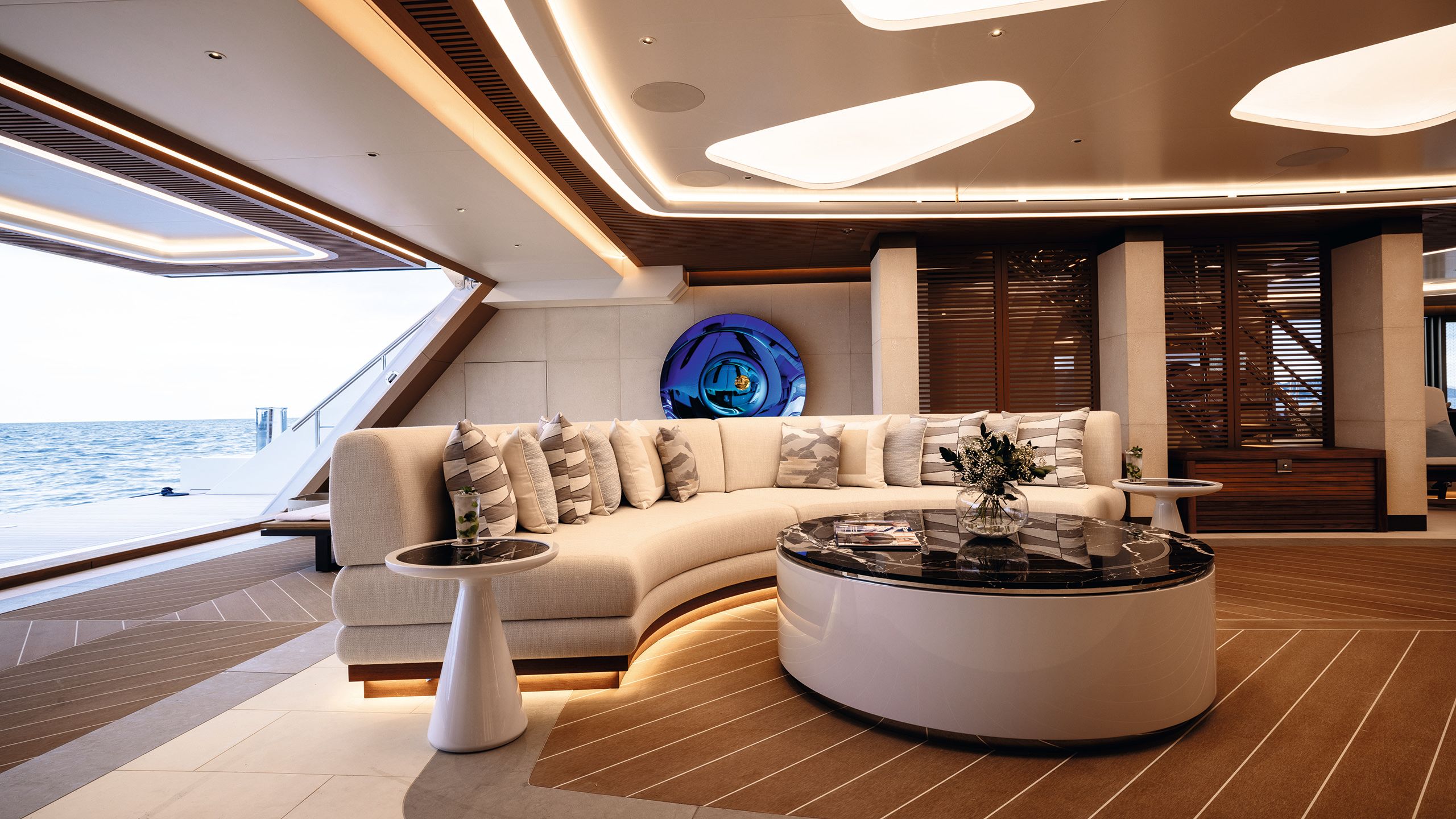Large curved sofa in cream with large coffee table at centre