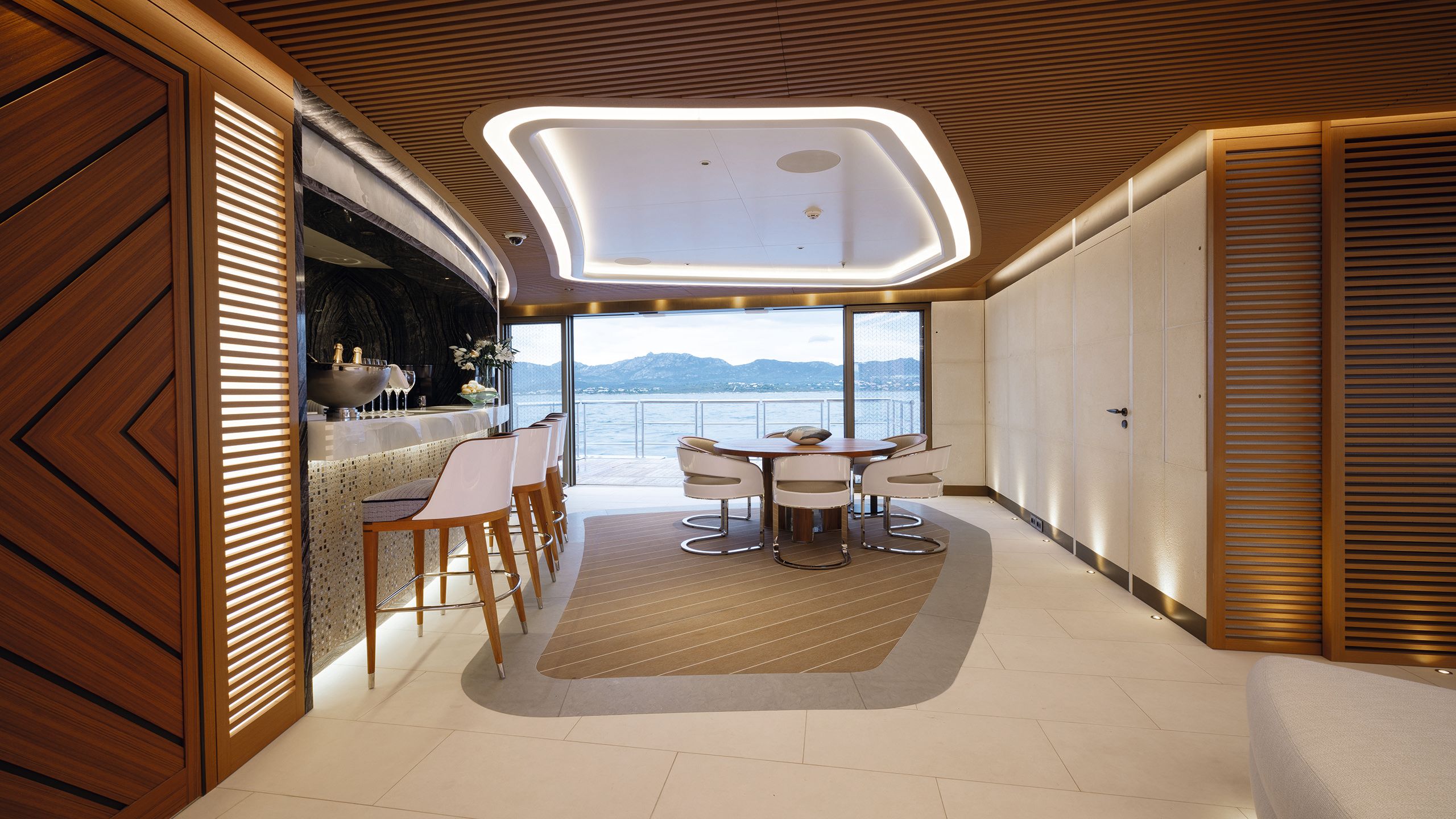 View of beach club with stools at the bar and table with chairs