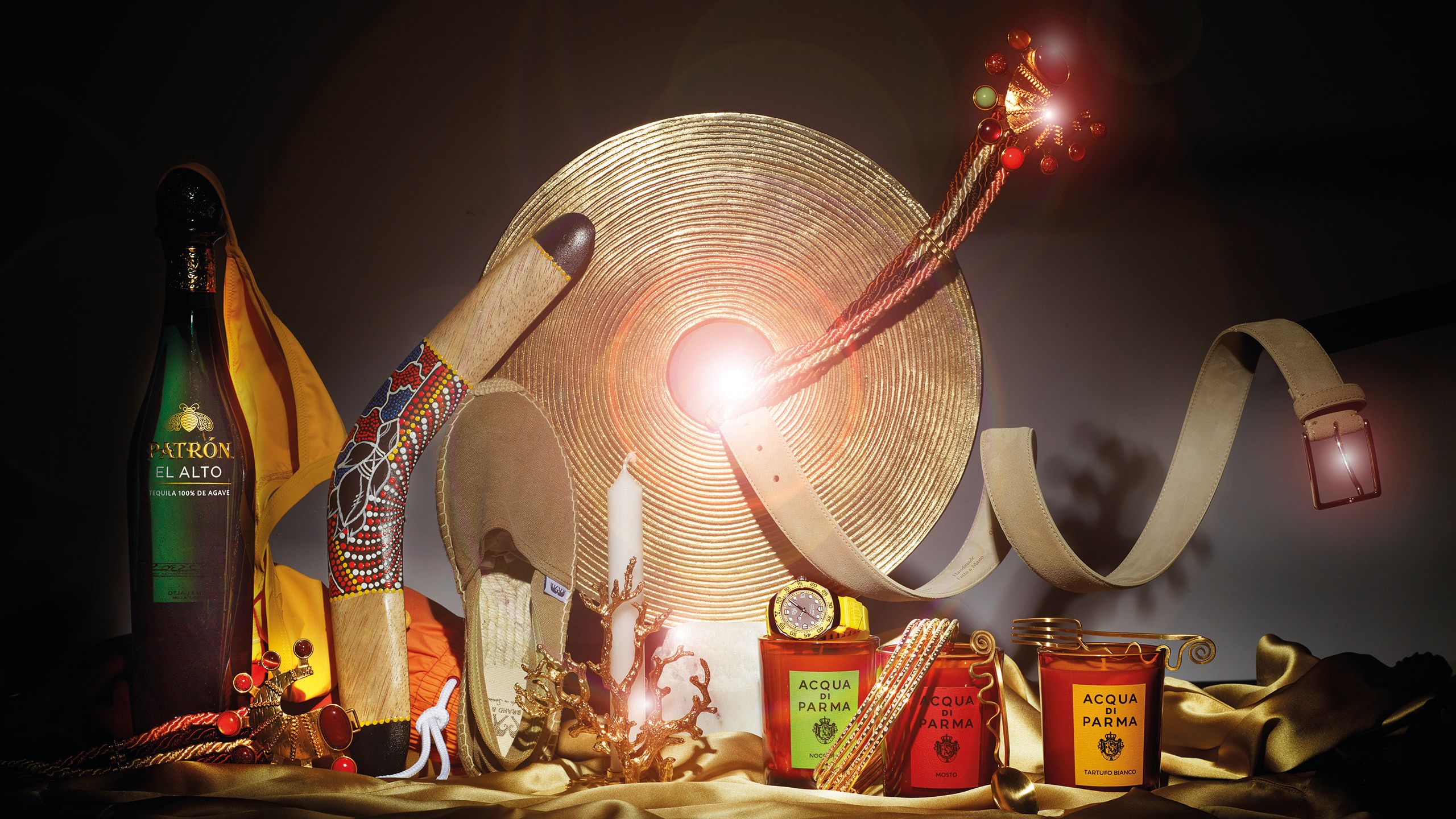 Gift guide in a red, black and gold colour palatte including tequila, Acqua di Parma candles, seahorse belt and bikini