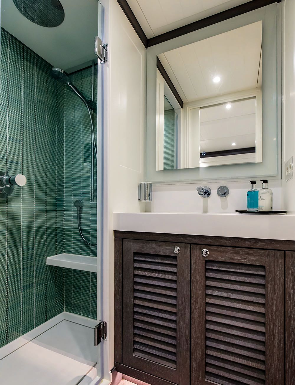Bathroom with white and green tiles, shower and sink