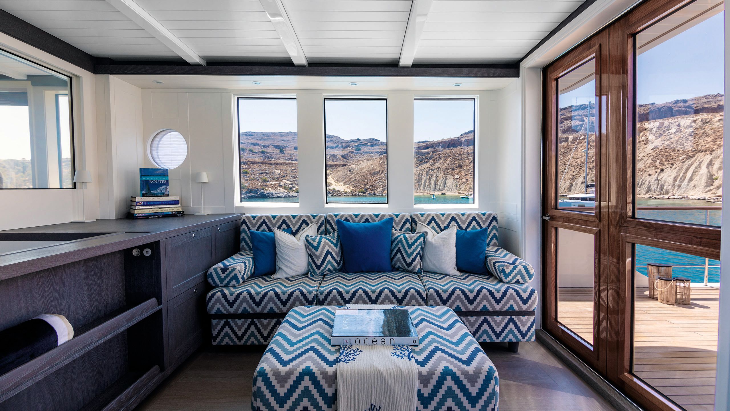 Small blue and white sofa with chevron print and matching footstool
