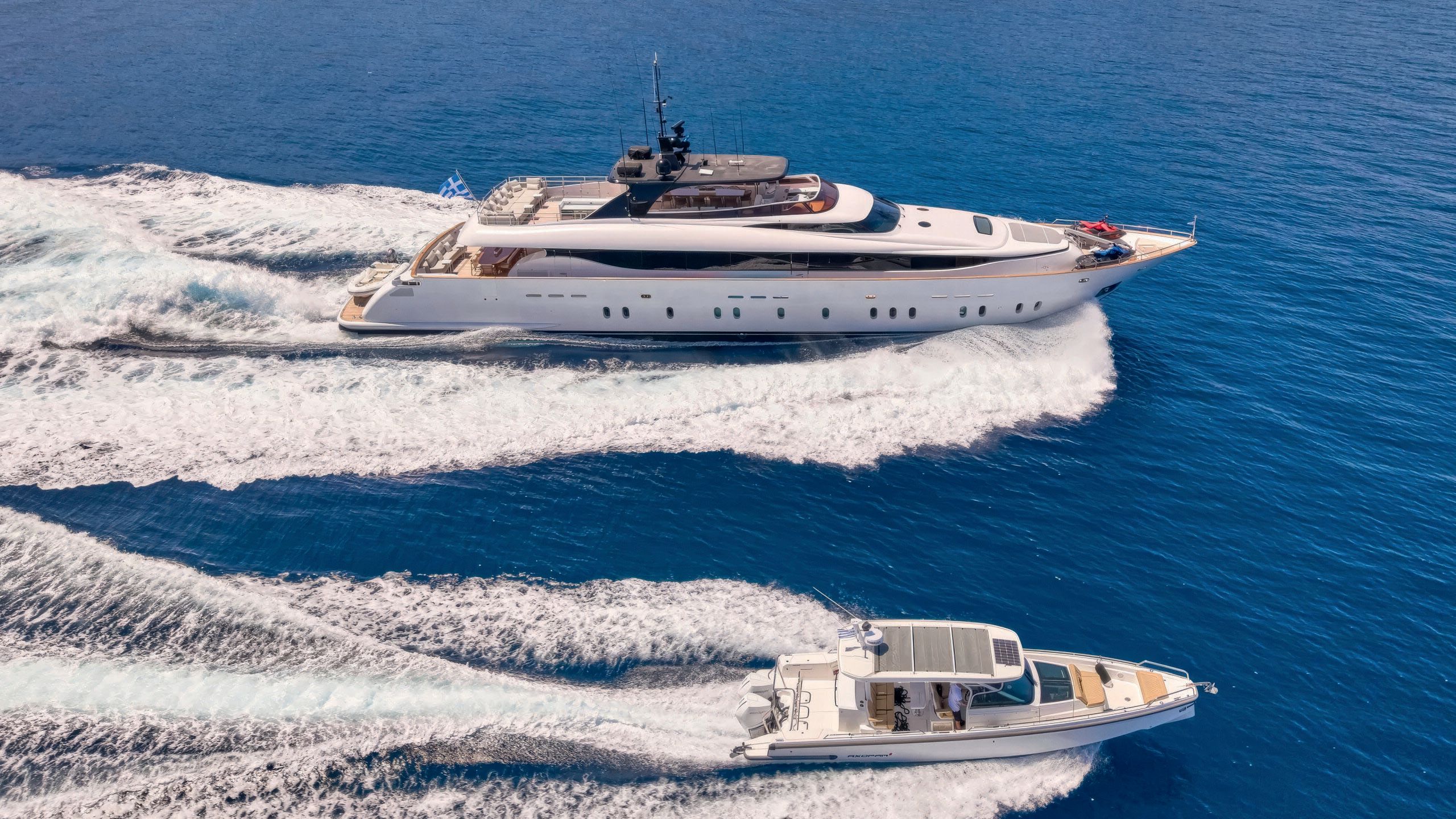 Mamma Mia in the background and the 12-metre tender at the front. Both are on the water and leaving frothy trails