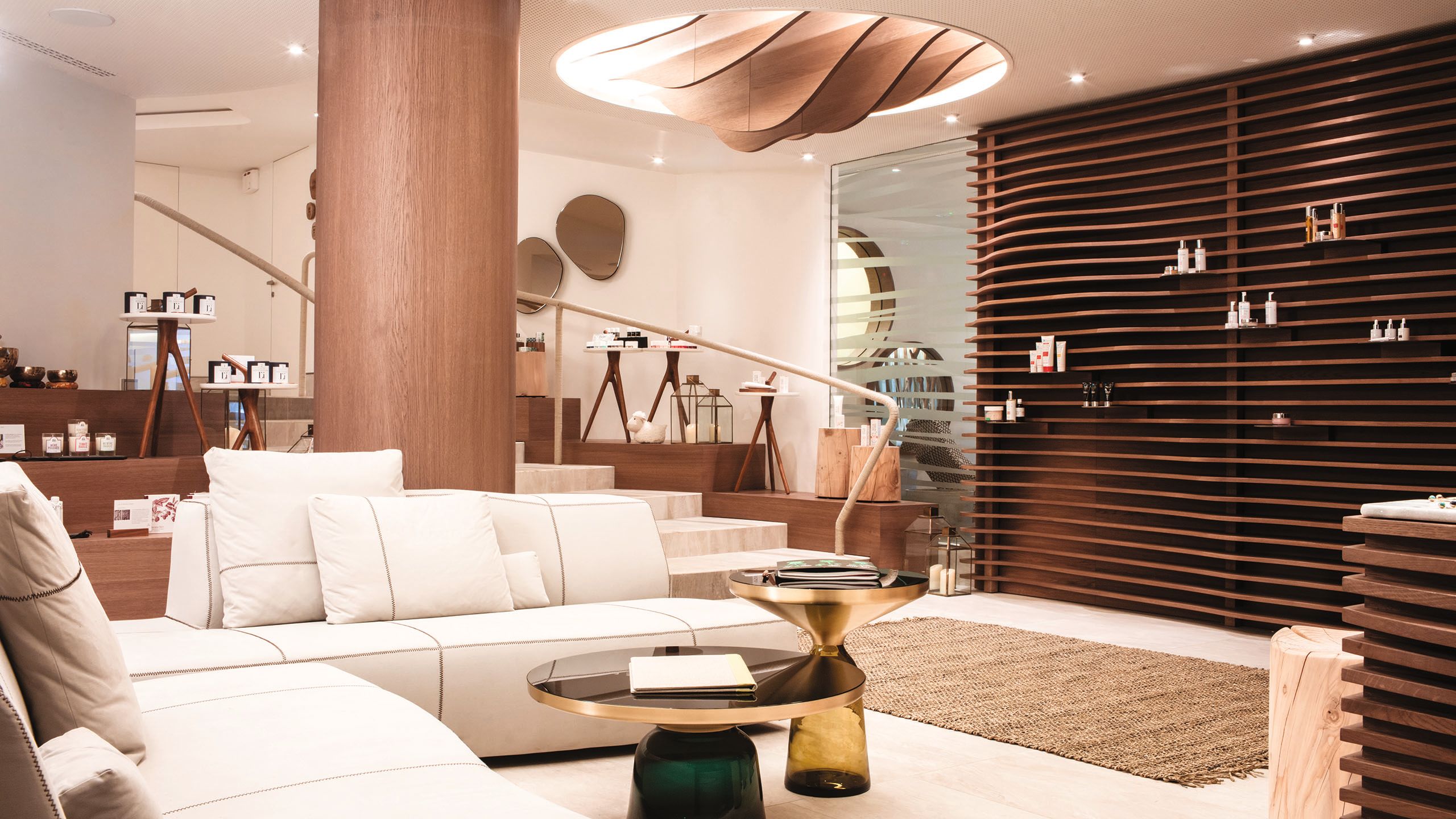 Cream sofas in a foyer with a black and gold table in front of them