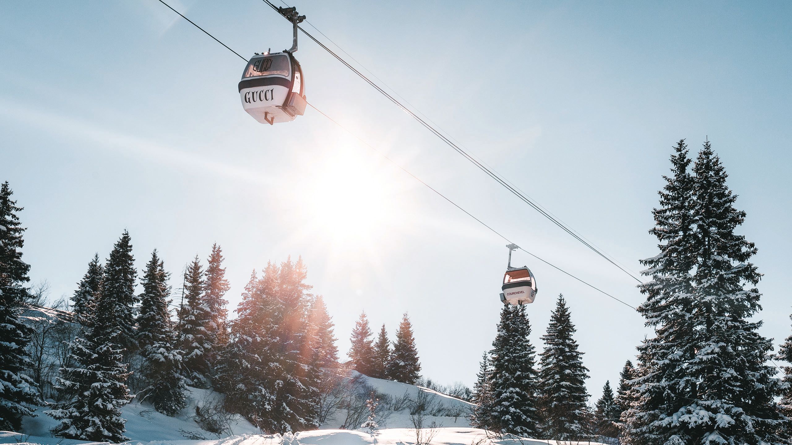 The sky gondola is red and white with Gucci written in black