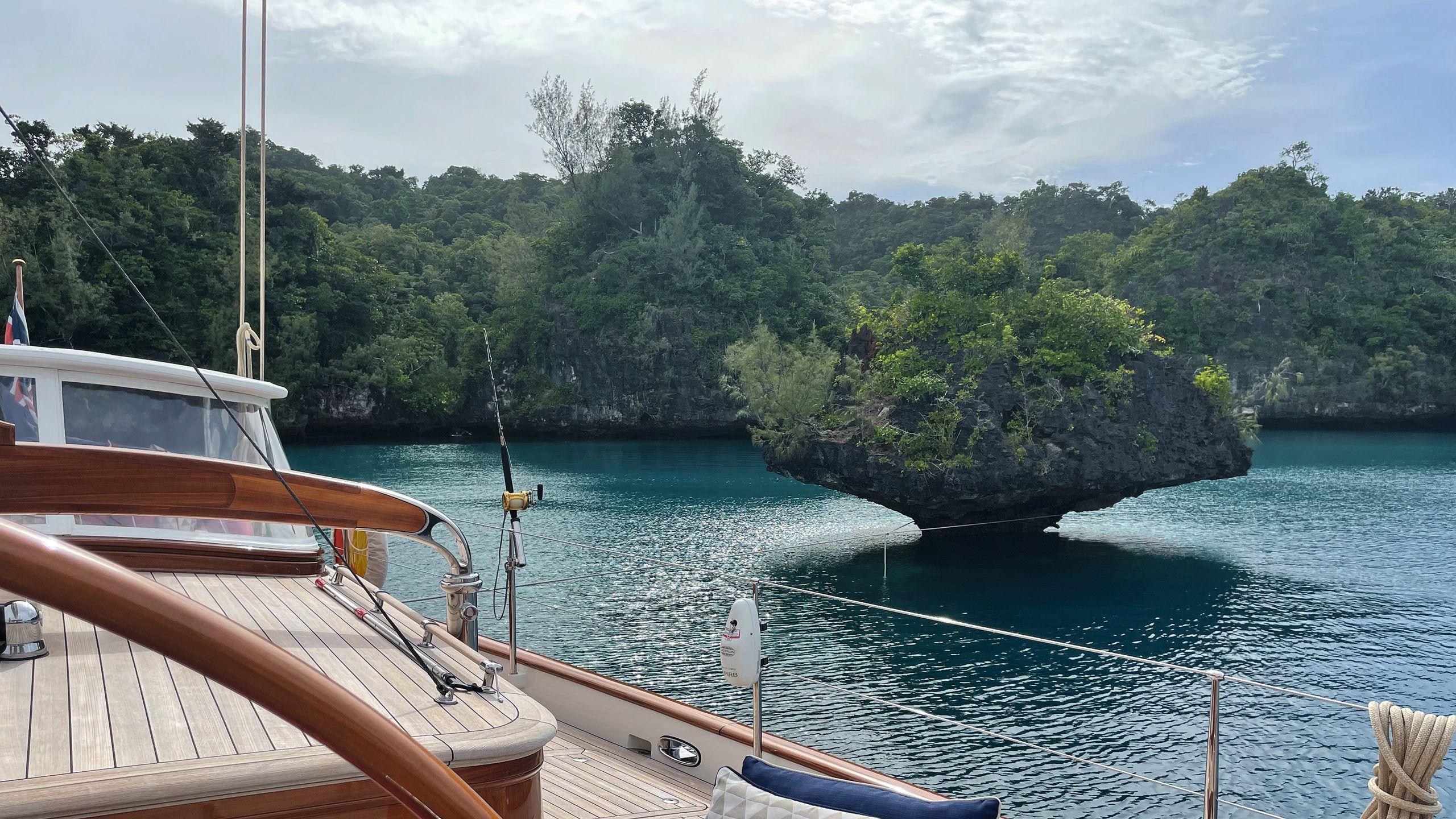 Side view of the boat taken from on board and looking out across the water to the trees