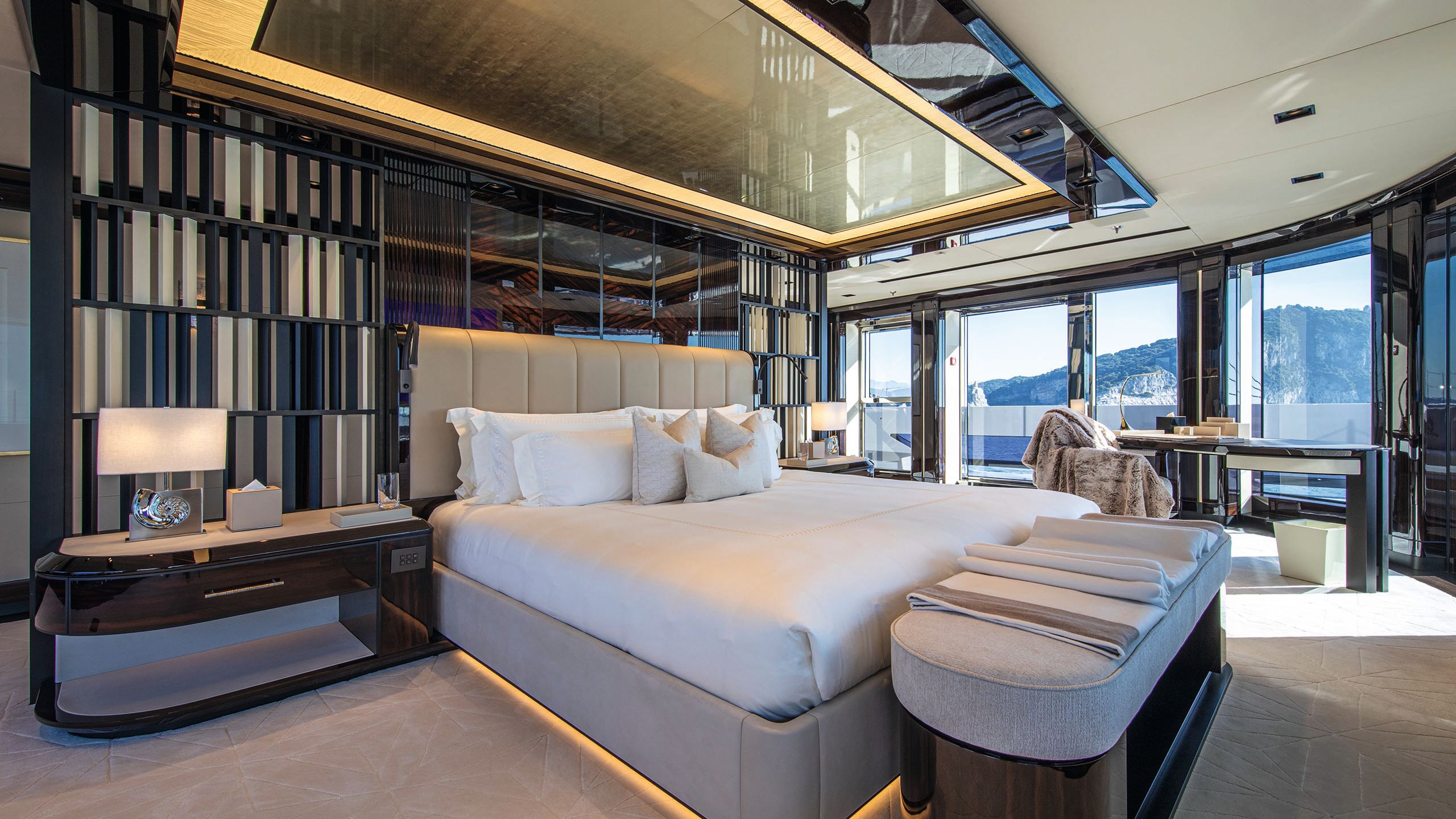 Large bed in the centre of the room with padded bench at the end. It's done out in neutrals and browns