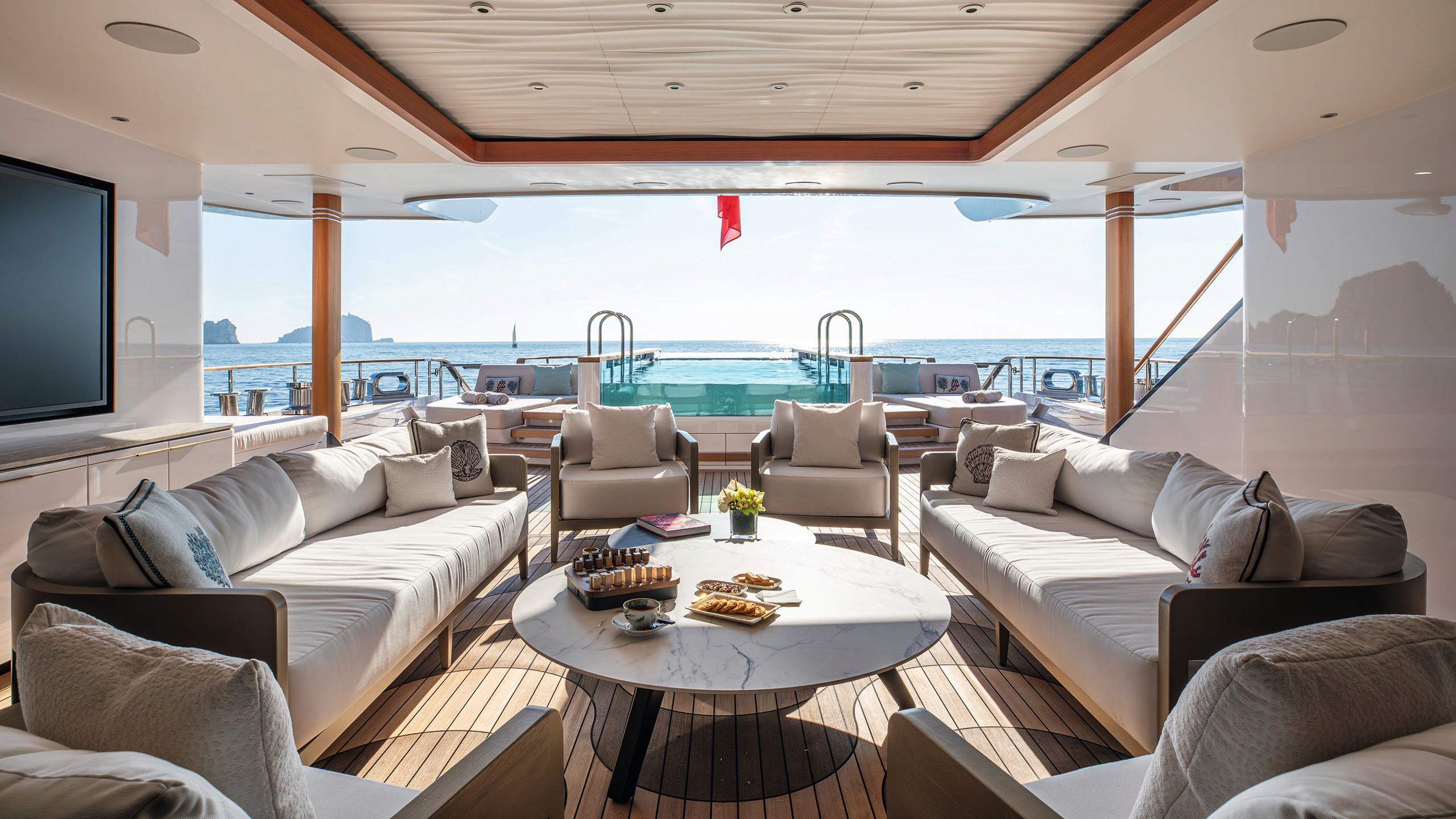 Looking out on to a covered outdoor deck with a pool in the background