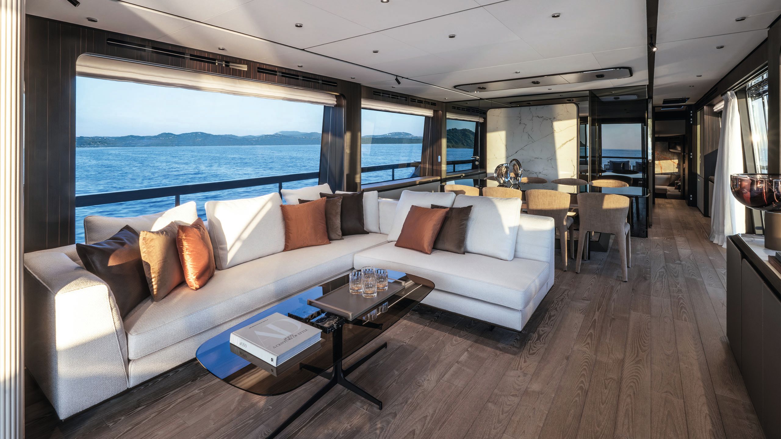 The saloon with a long L-shaped white sofa. The floor is dark wood