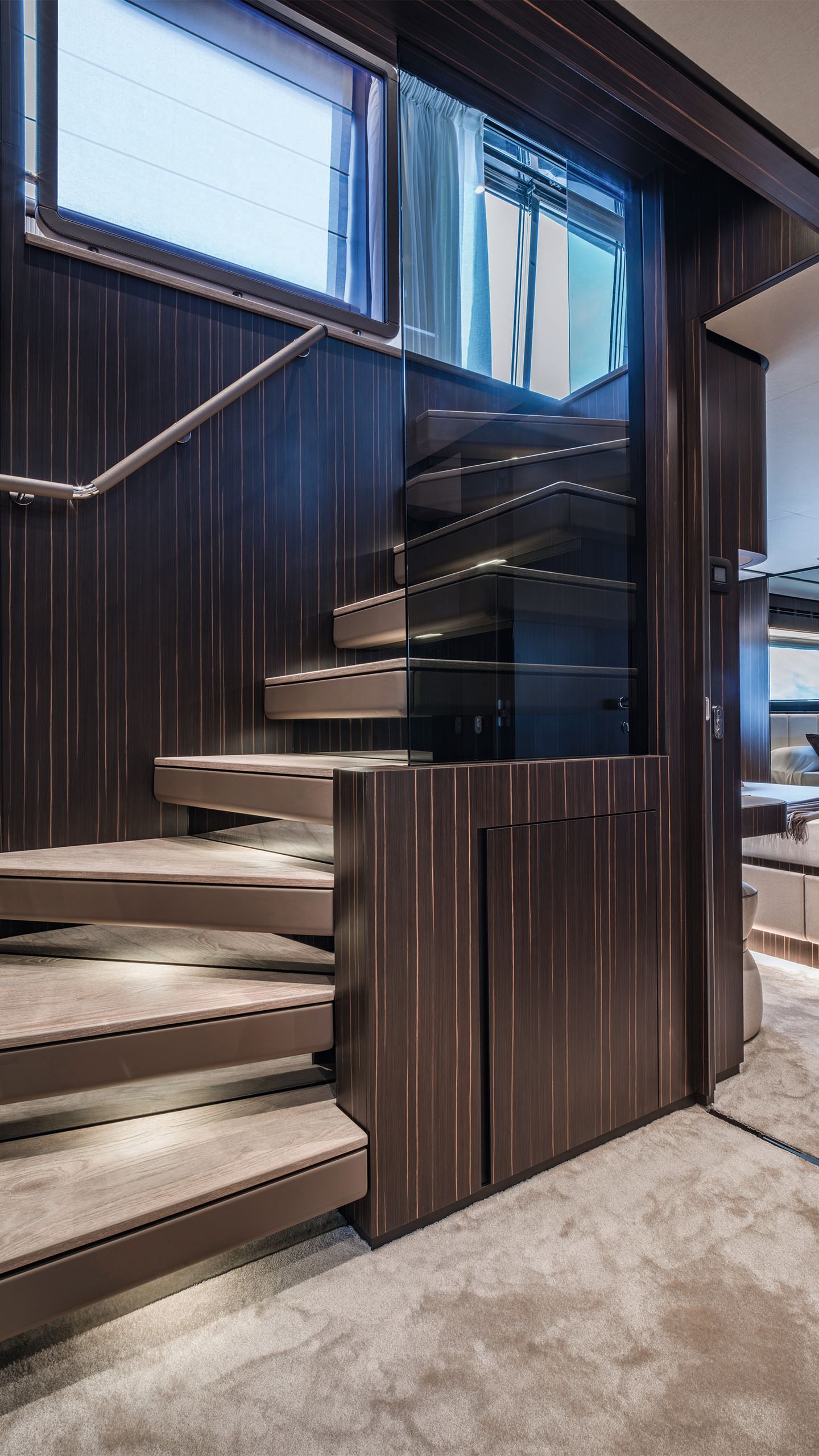 Looking up from the bottom of a dark wood staircase with lighter treads