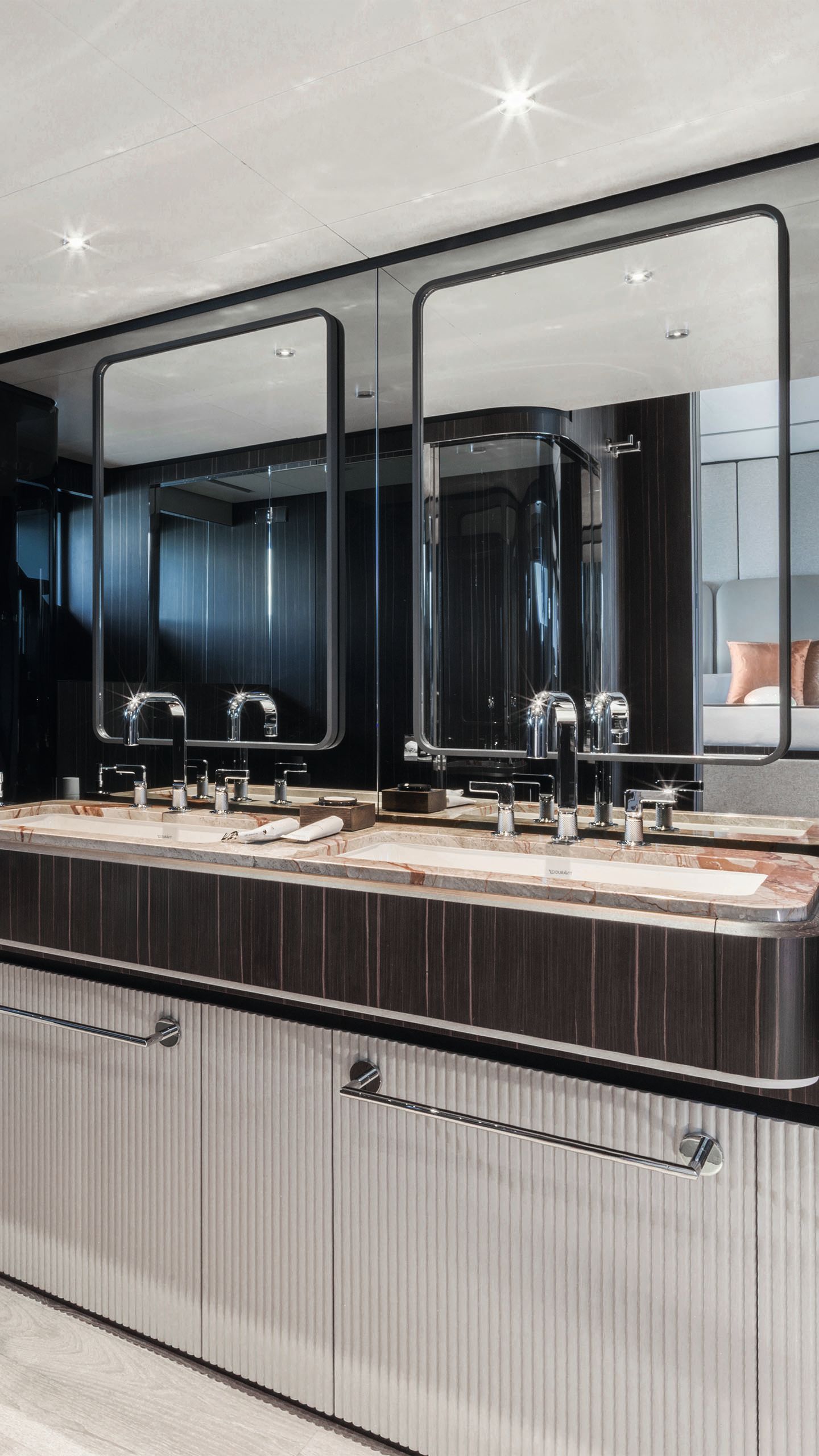 Inside the en-suite bathroom which has black counter tops and white cupboards below