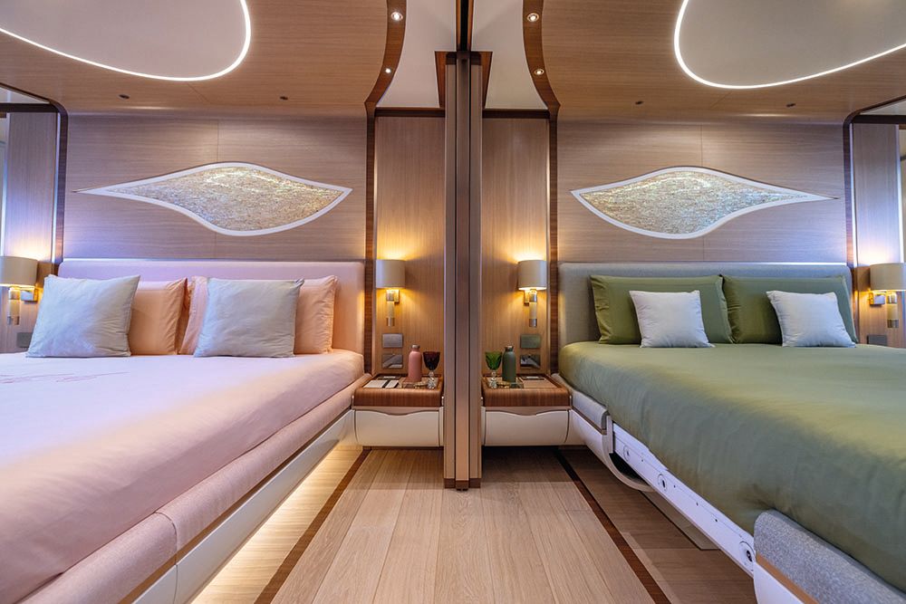 Front view of two double beds side by side - one has pink linens and the other has green