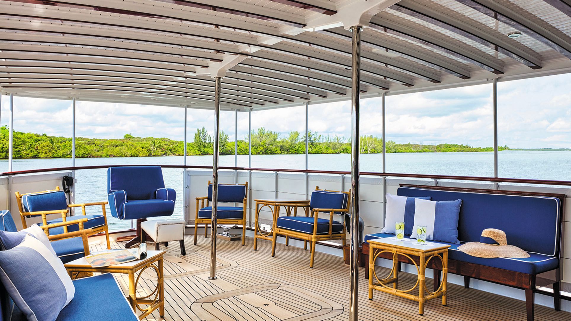 Bamboo armchairs and tables with blue cushions on the covered deck