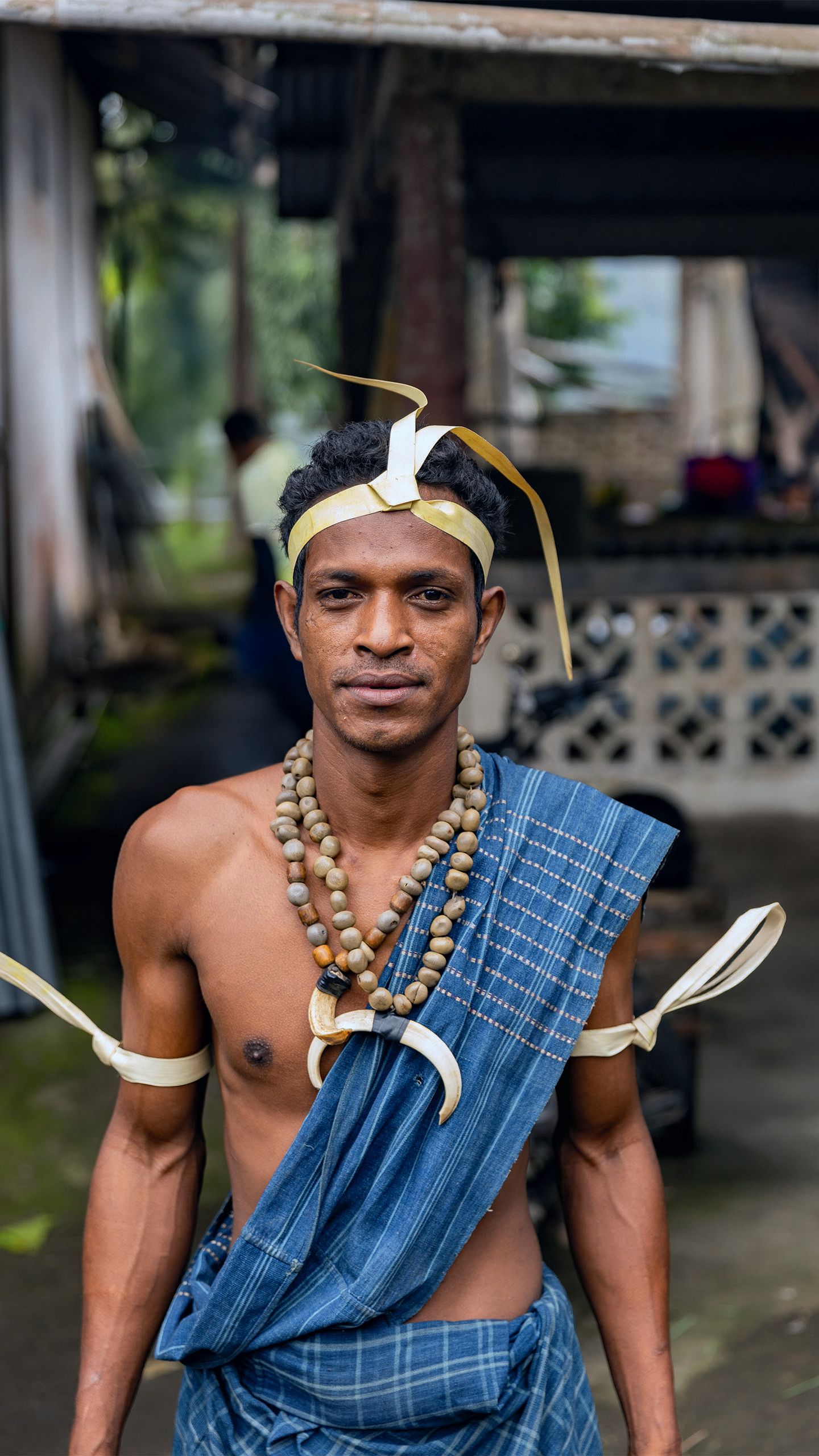 A man in traditional dress, jewellery and headwear