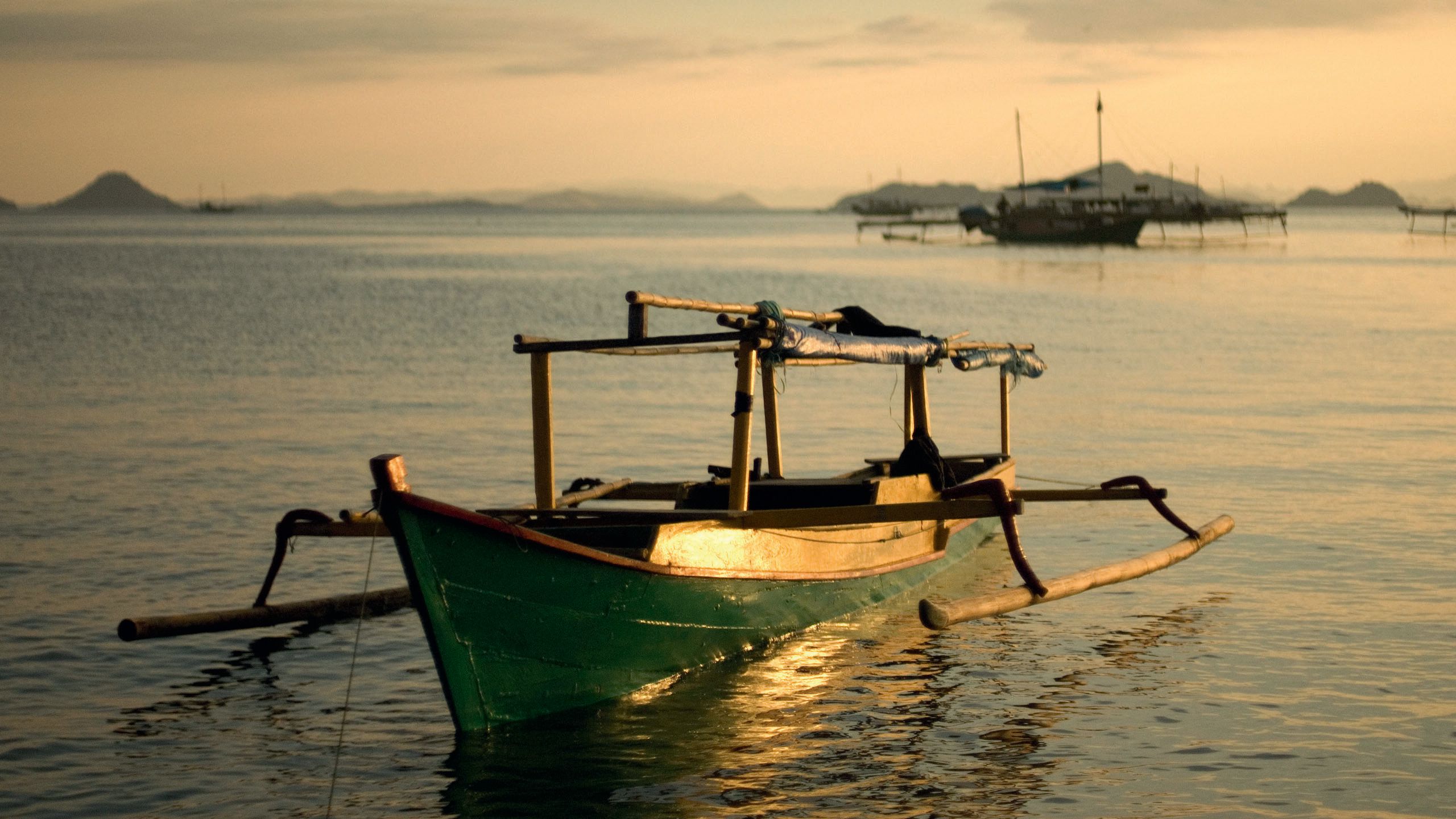 A jukung boat anchored in shallows at sunrise/sunset