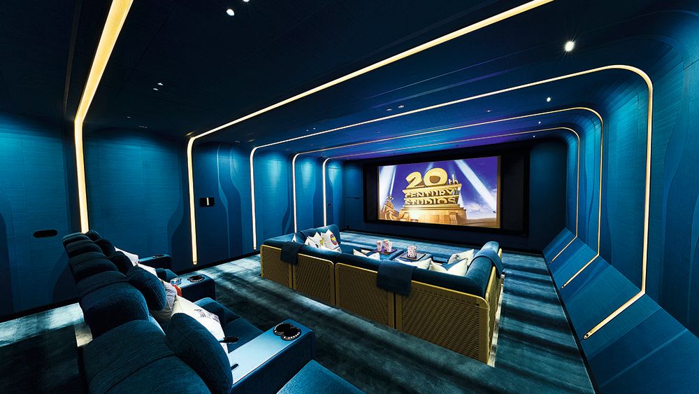Inside the cinema which has blue walls and a sofa and cinema seats