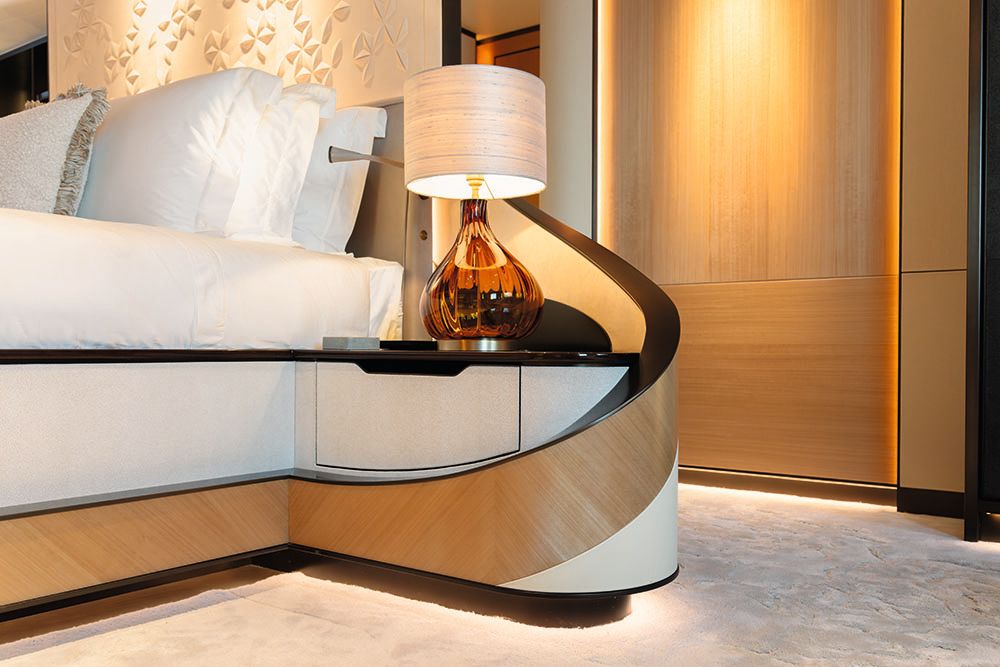 The headboard curves around to encase the bedside table which has a lamp on it