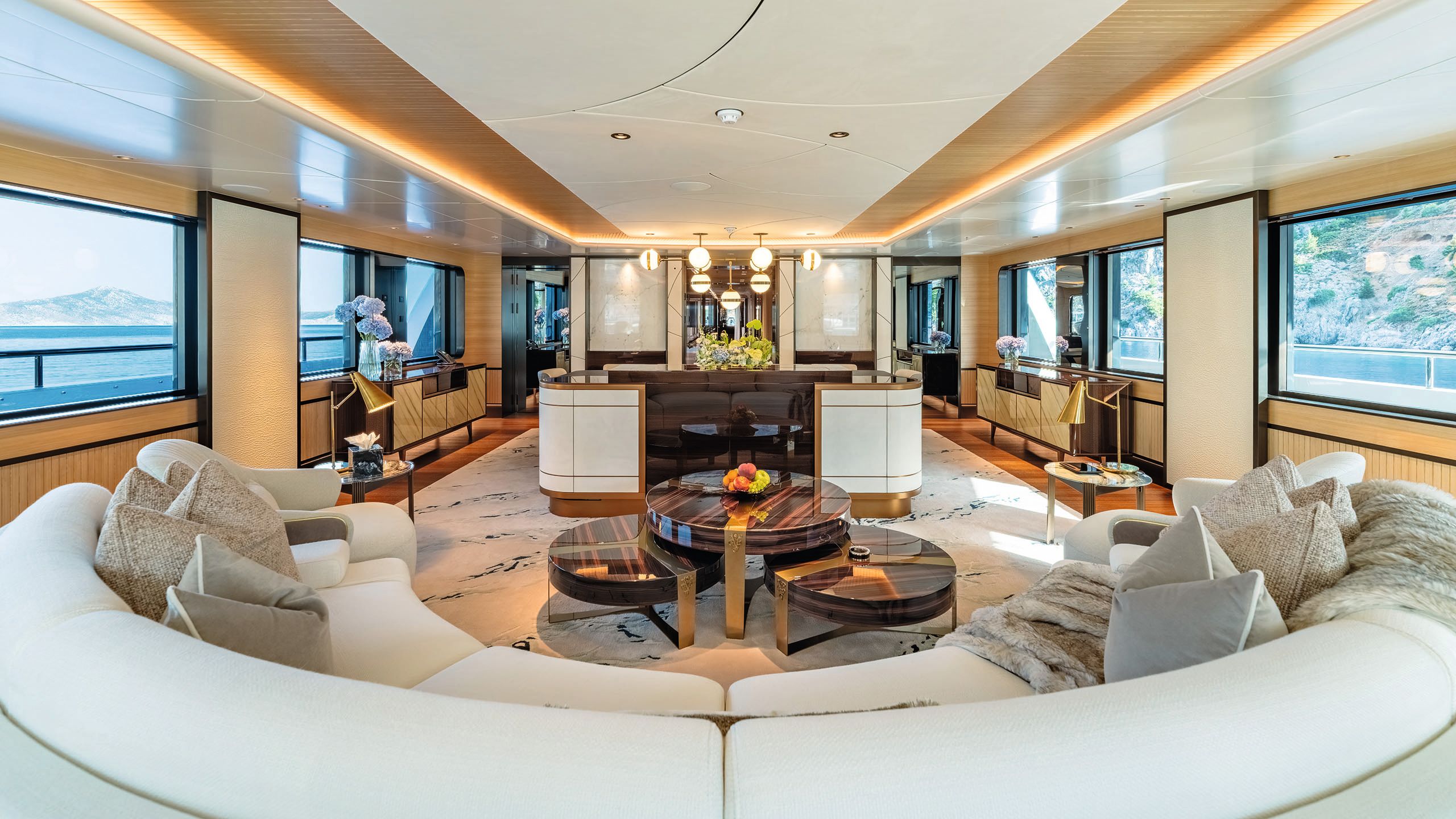 Large curved white sofa in the foreground, looking into the upper saloon