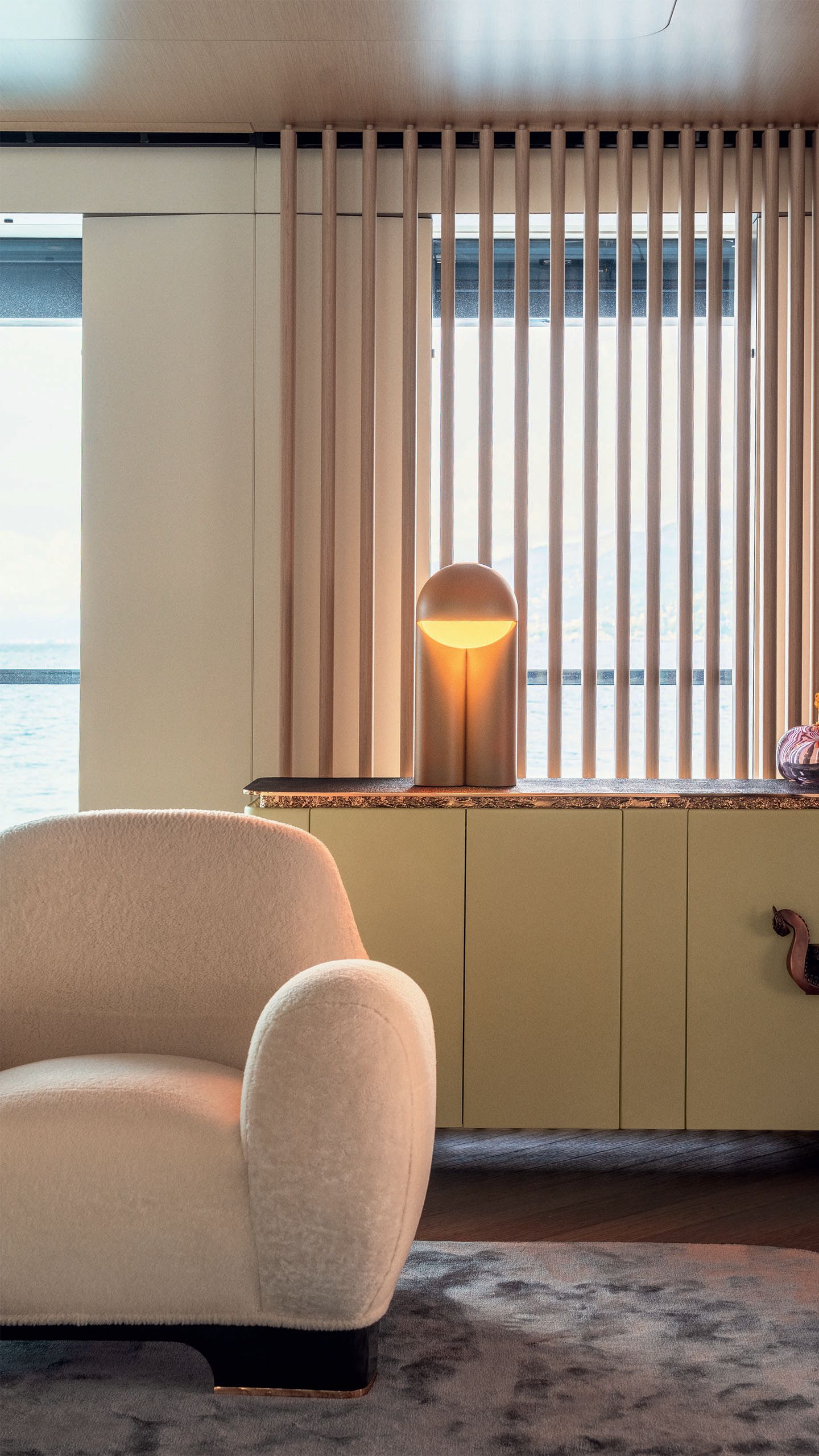 A beige armchair and lamp behind it