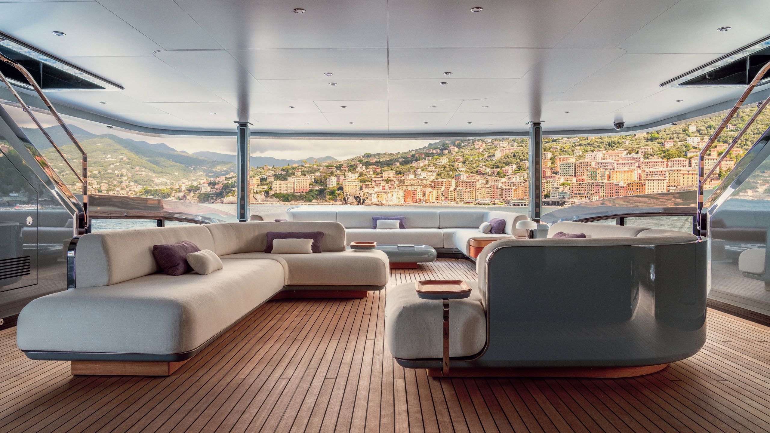 Covered outdoor deck area with L-shaped sofas in neutral tones