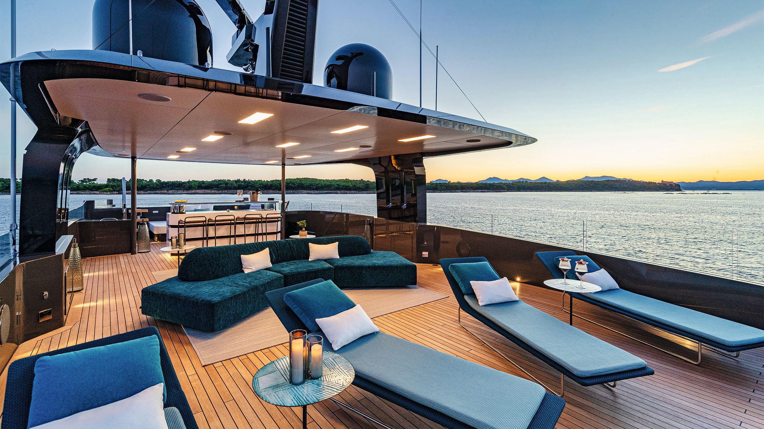 Sun deck with blue sunloungers and curved sofa behind