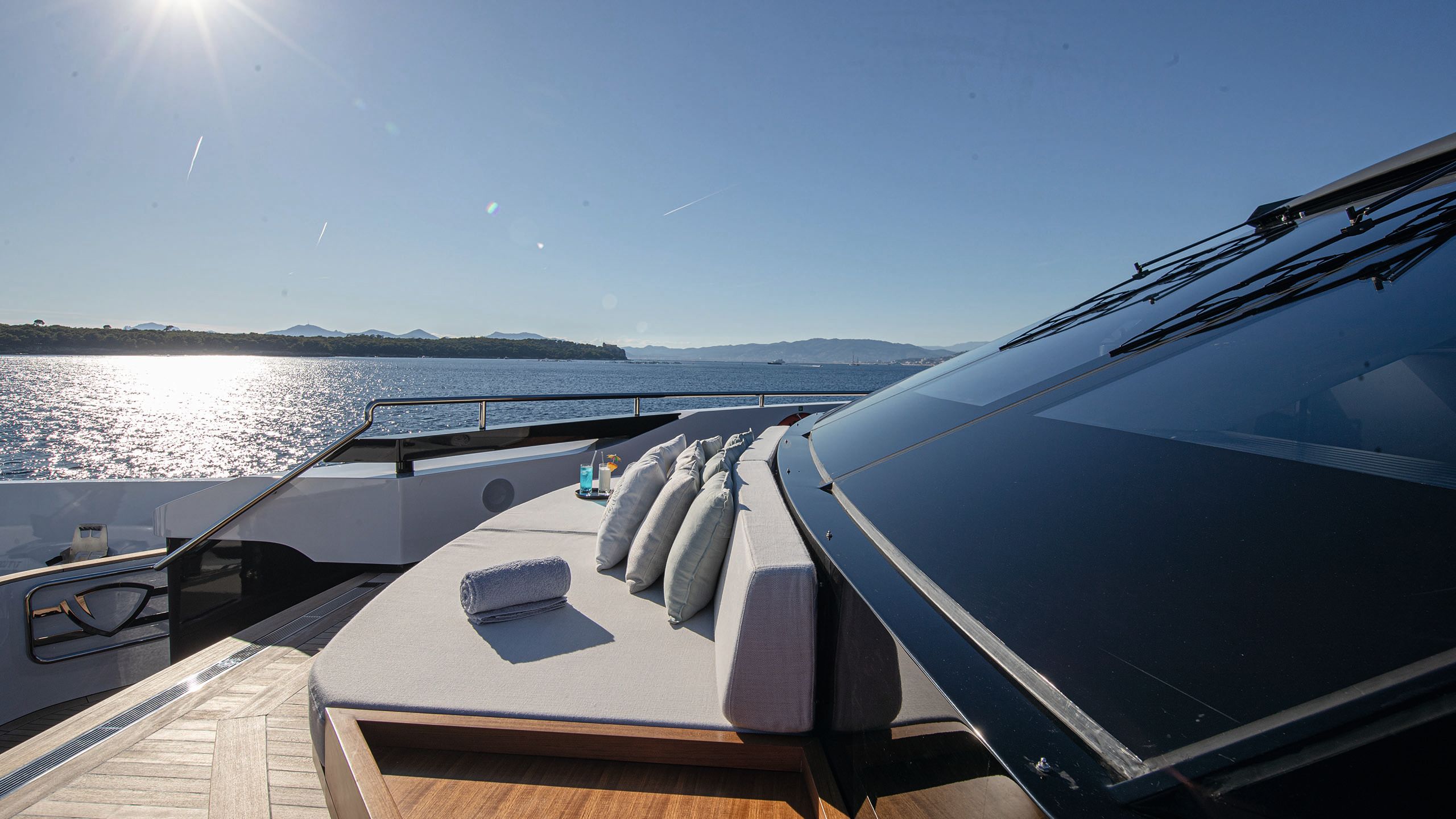 Large grey sun pad with cushions and towels