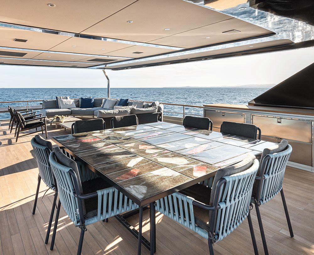 Square dining table on an outdoor deck with seats for eight