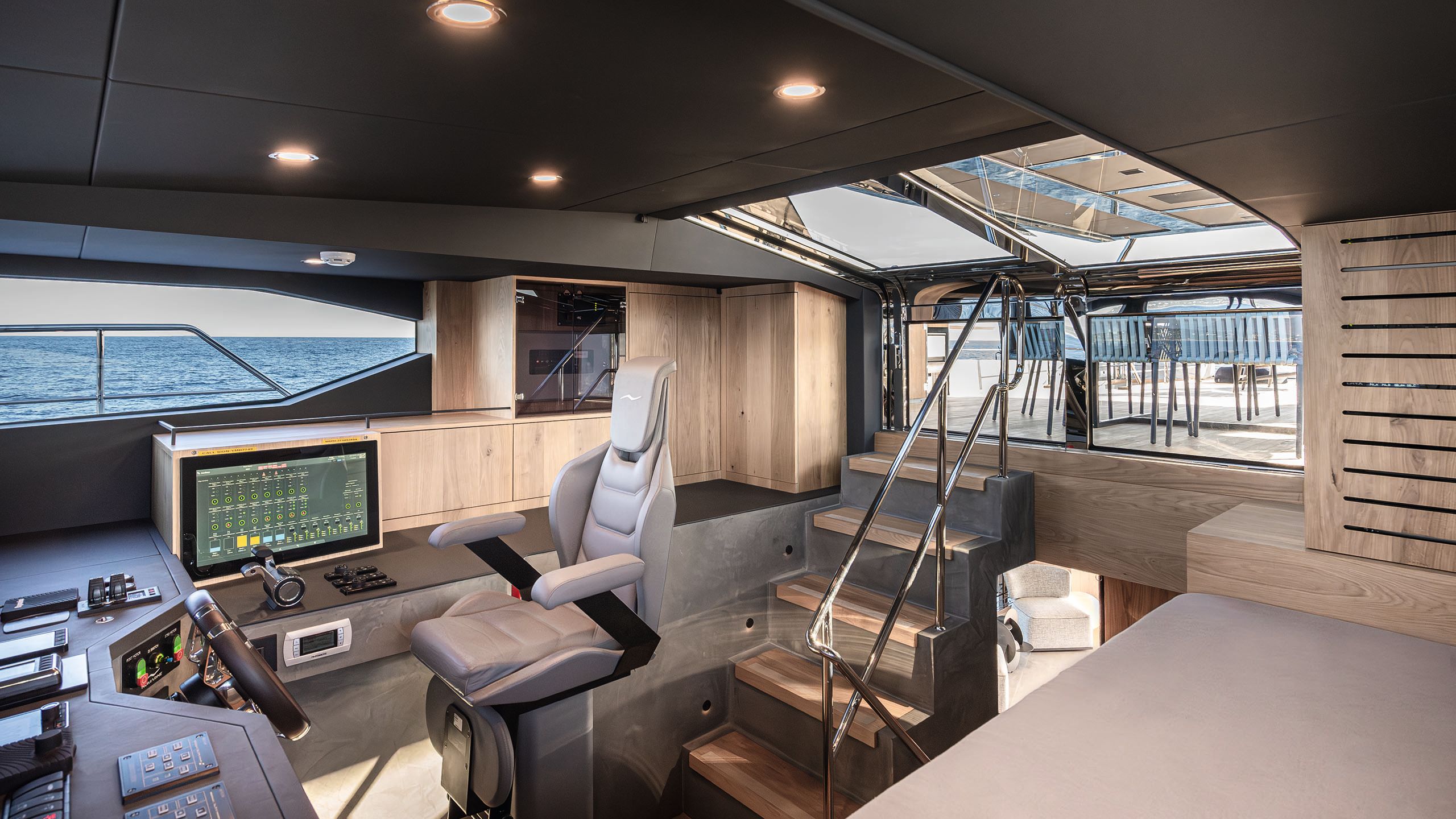 Bridge room with large grey chair at the centre, opposite the steering wheel