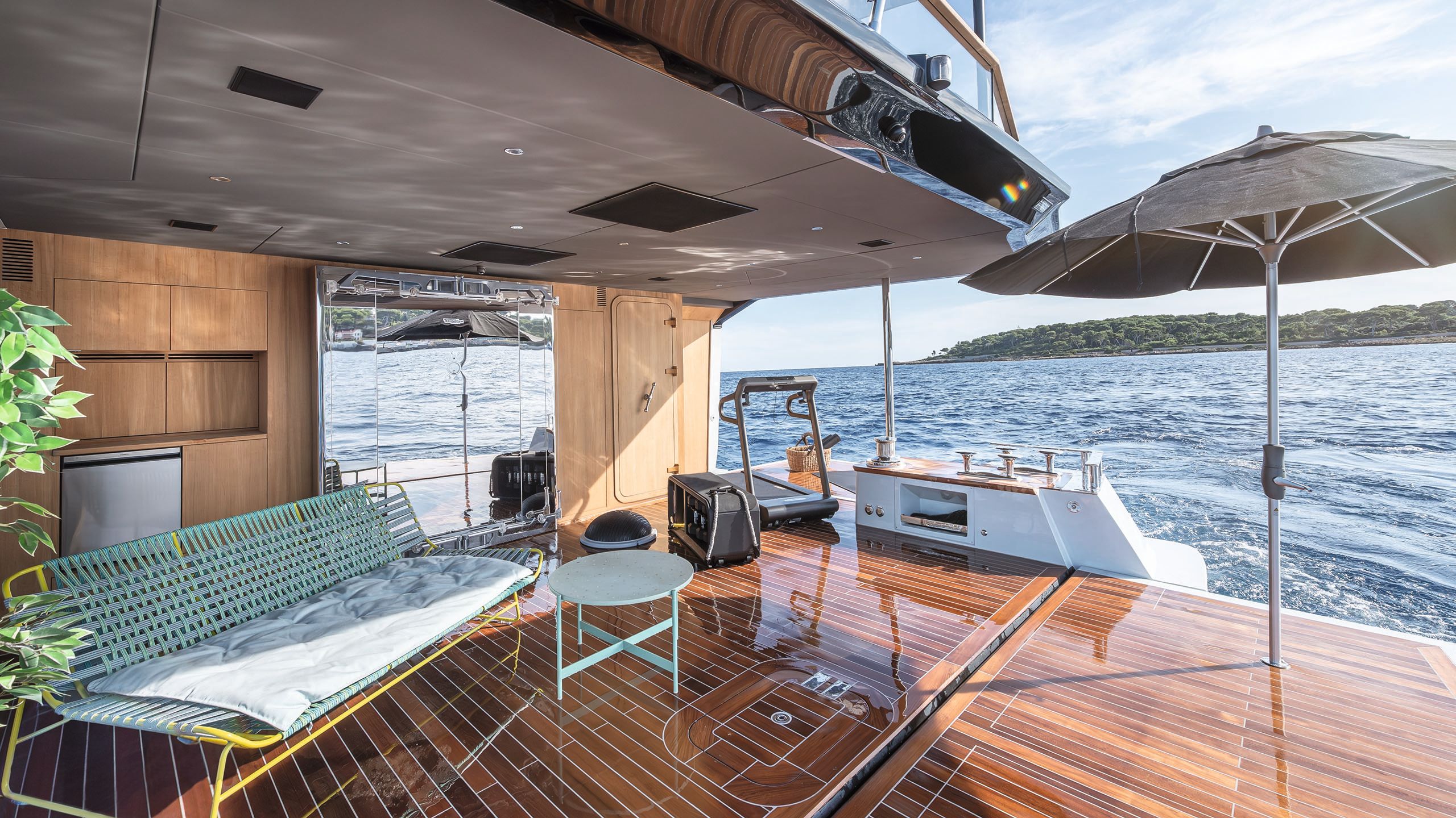 Outdoor gym area with treadmill, outdoor seating and a parasol