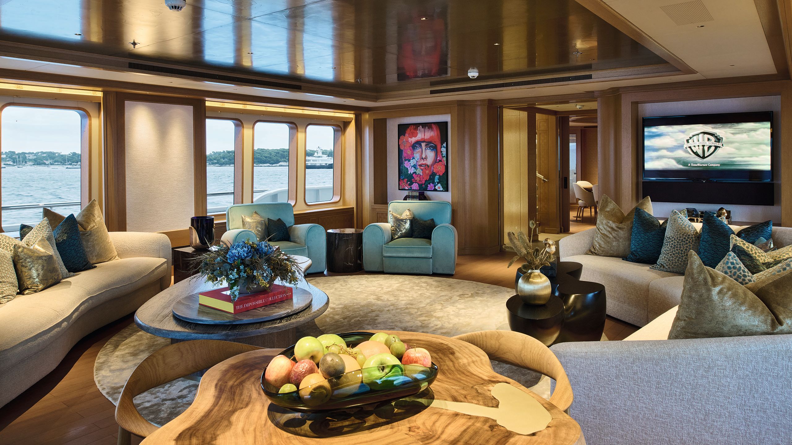 Inside the salon which has blue armchairs, neutral sofas and colourful art on the wall