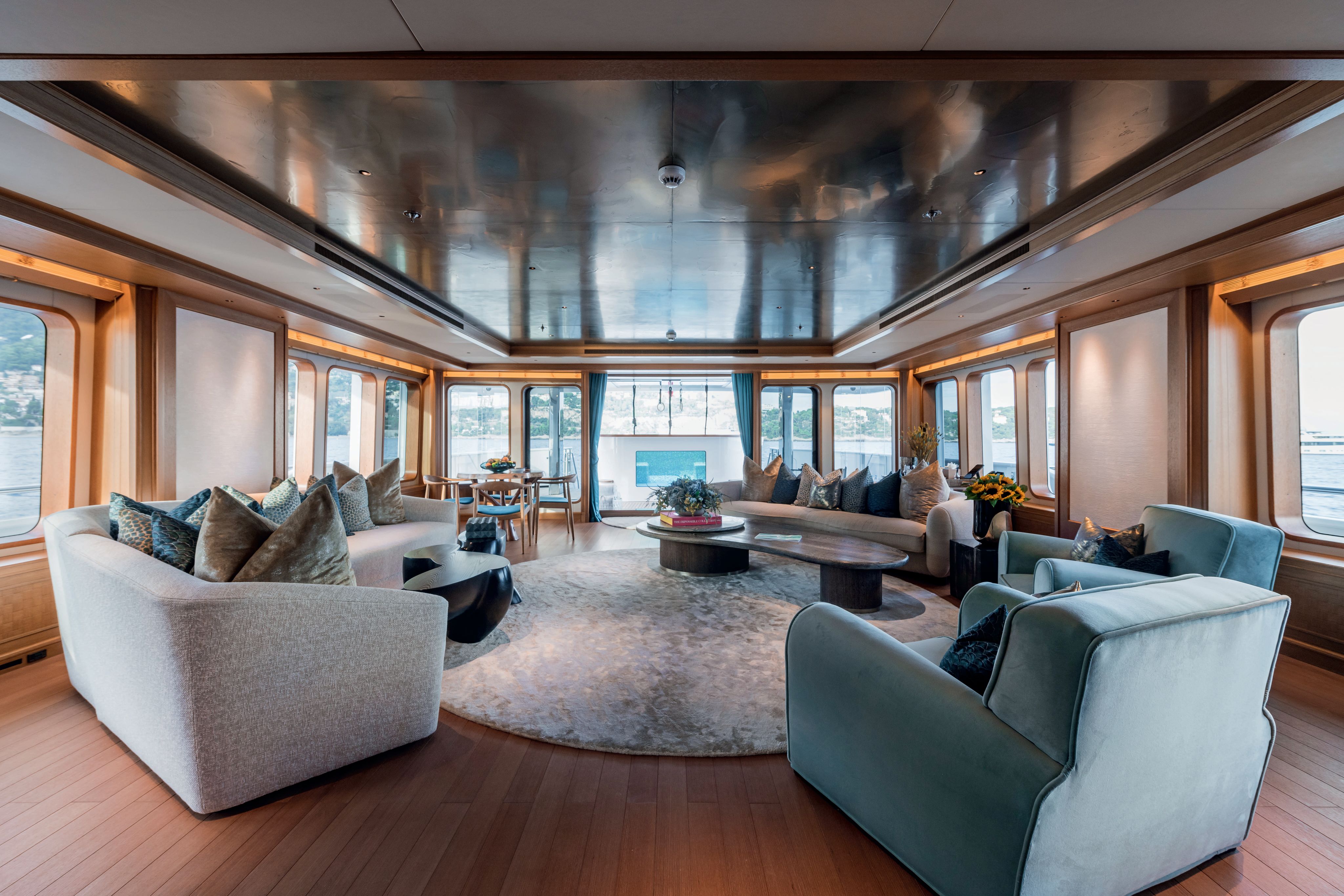 Inside the salon which has blue armchairs, neutral sofas and colourful art on the wall