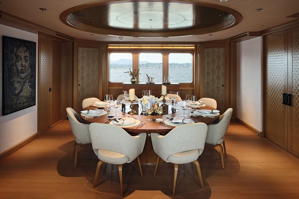 A round dining table with eight white chairs around it