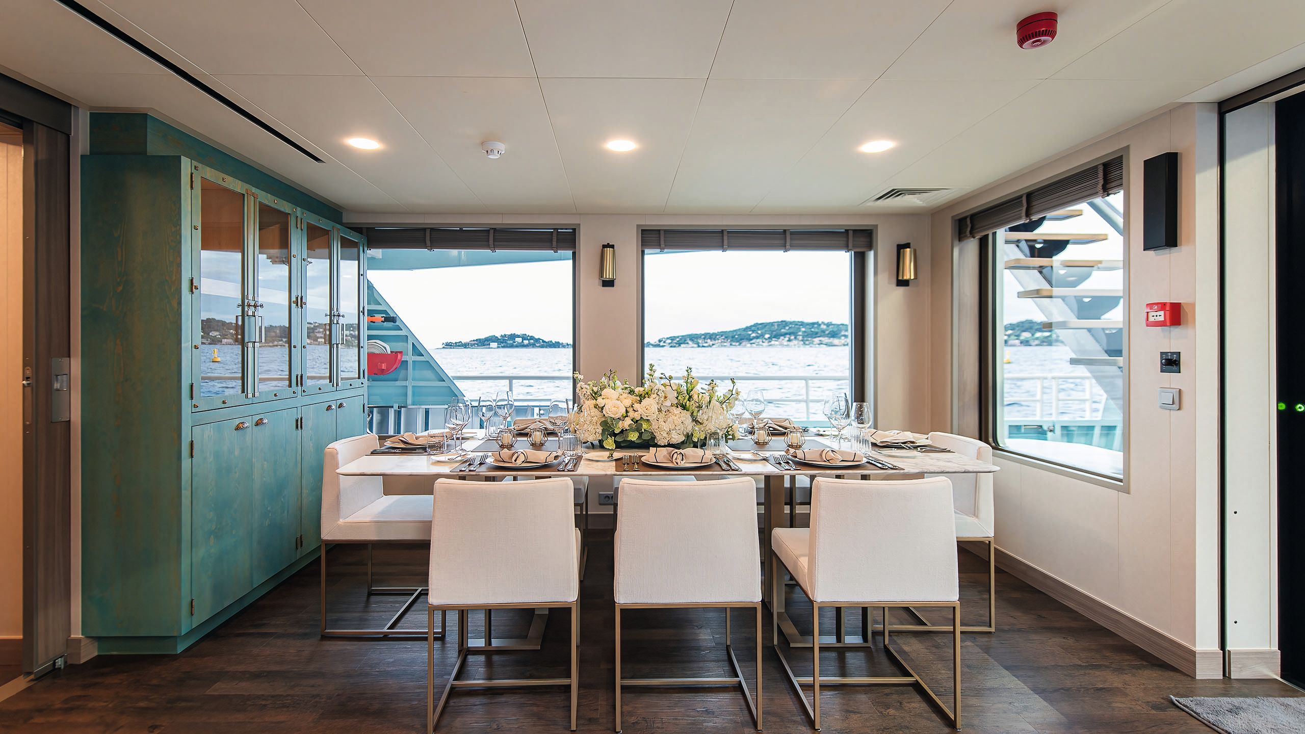 Alternative view of the dining table which has a large sideboard with cupboards and glass doors to the left